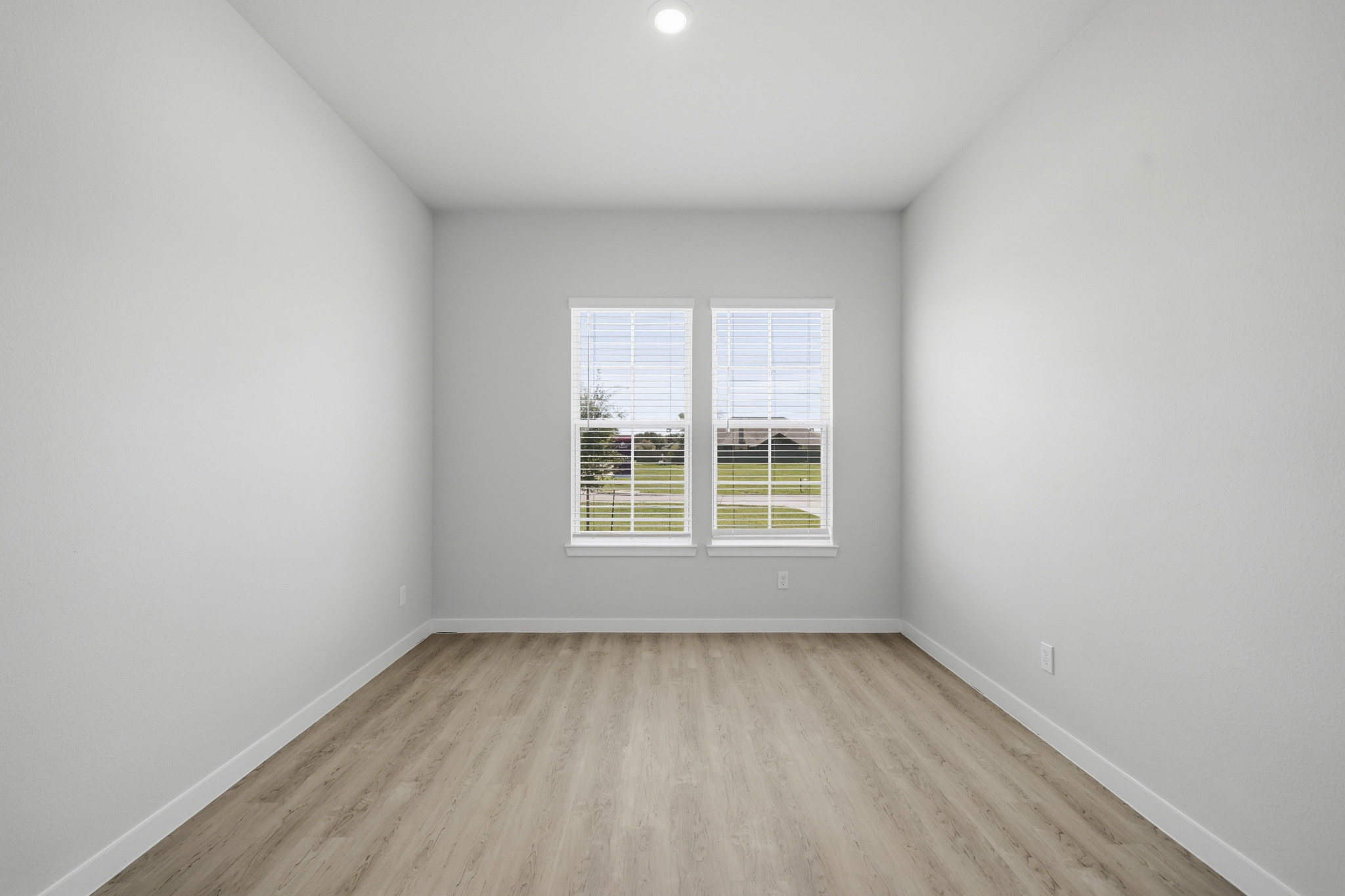 A room with a wood floor and a window.