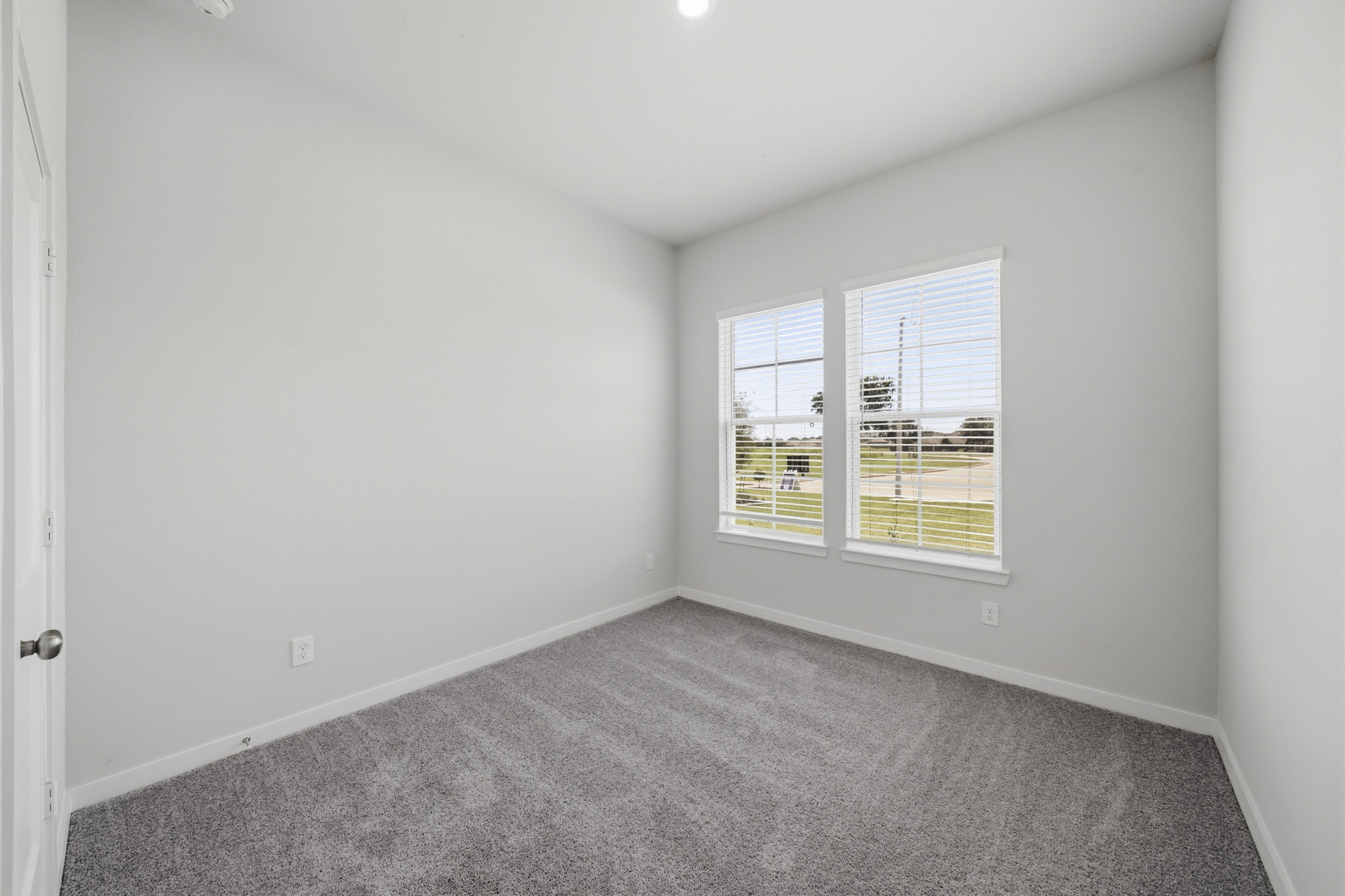 A room with a carpet and windows.