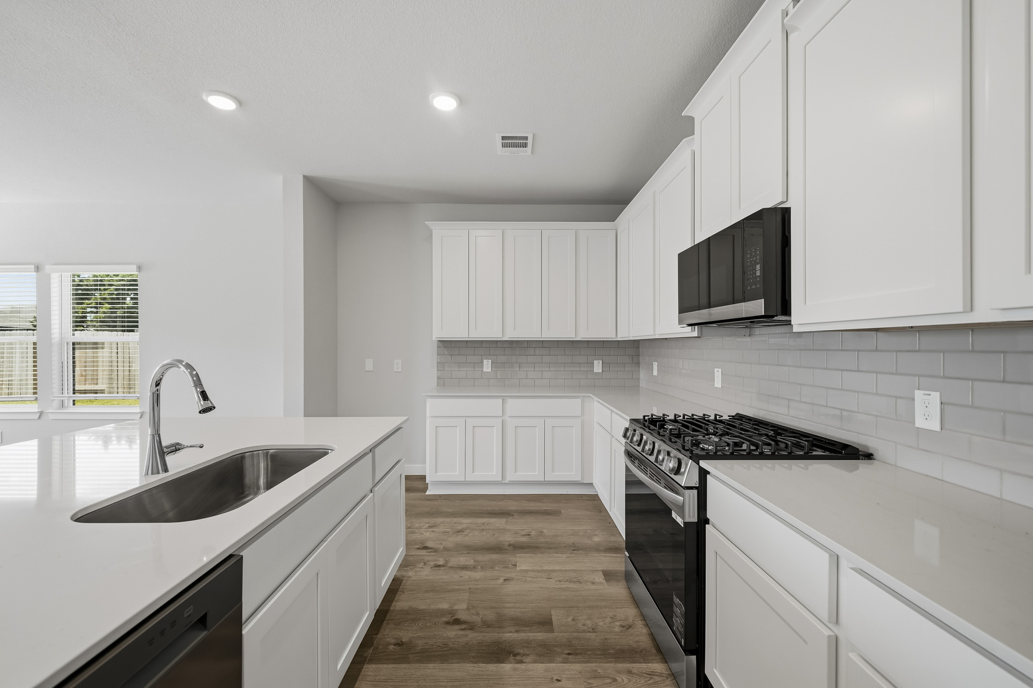 A kitchen with white cabinets.