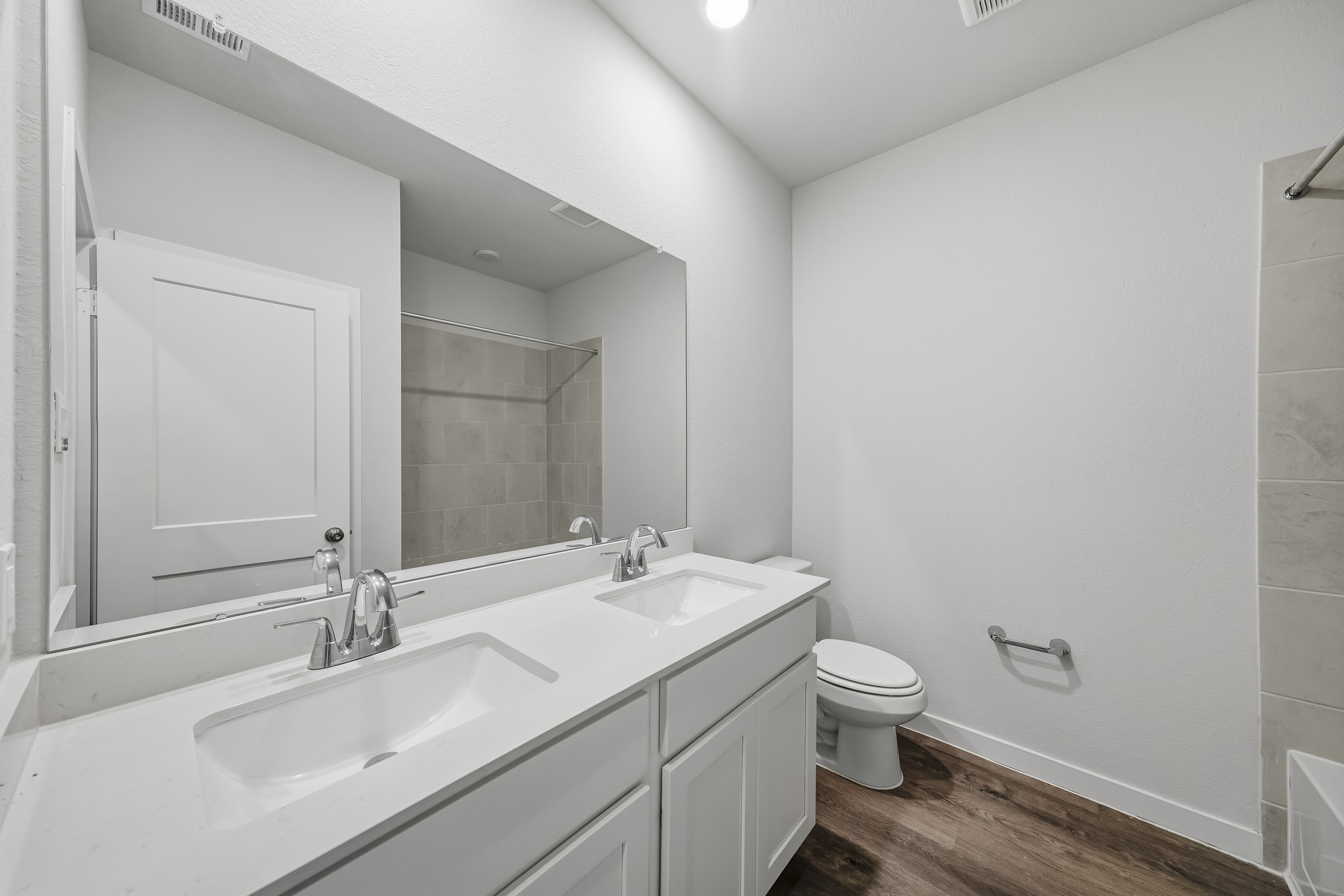 A bathroom with a sink toilet and mirror.