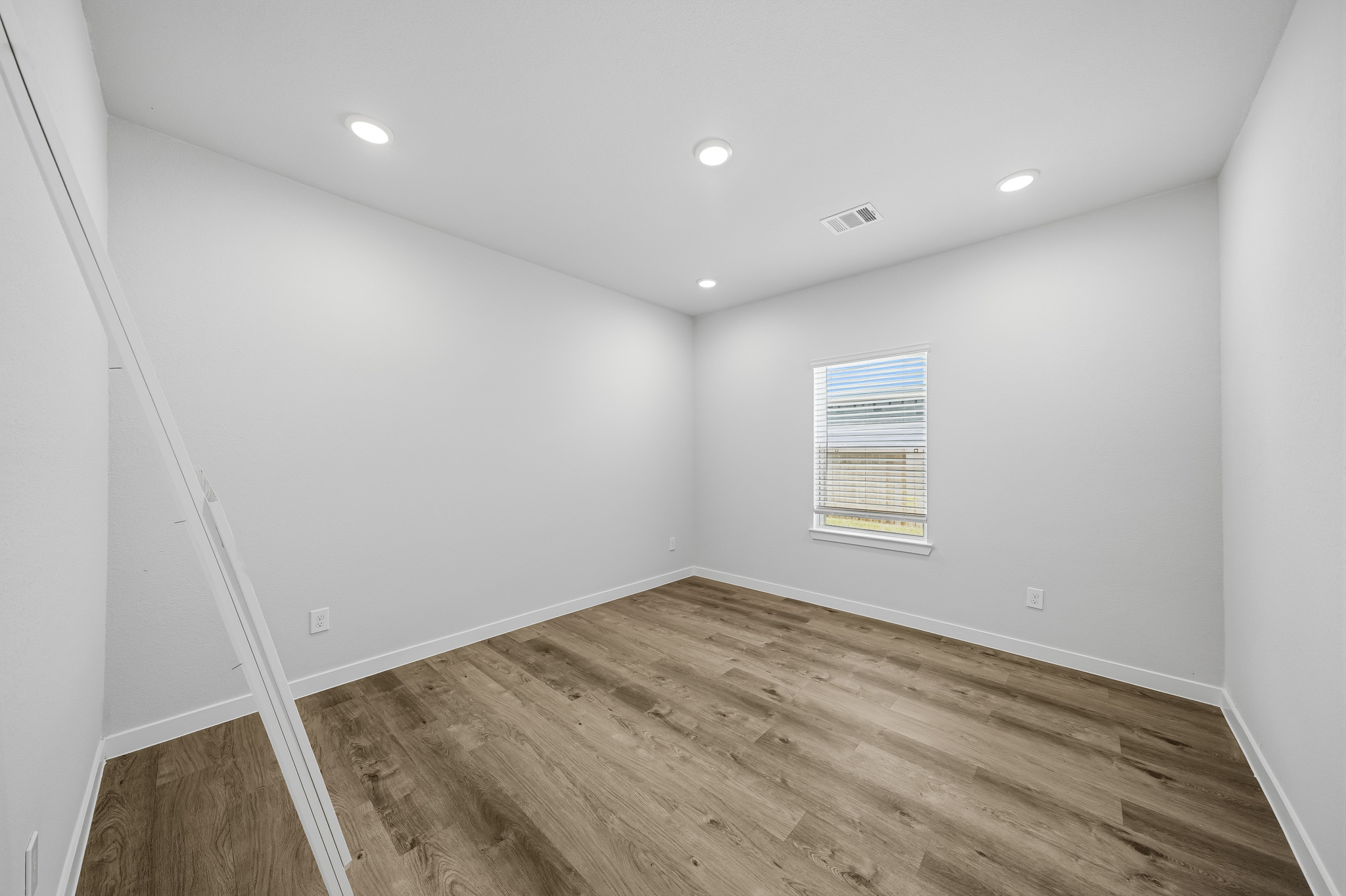 A room with a wood floor and white walls.