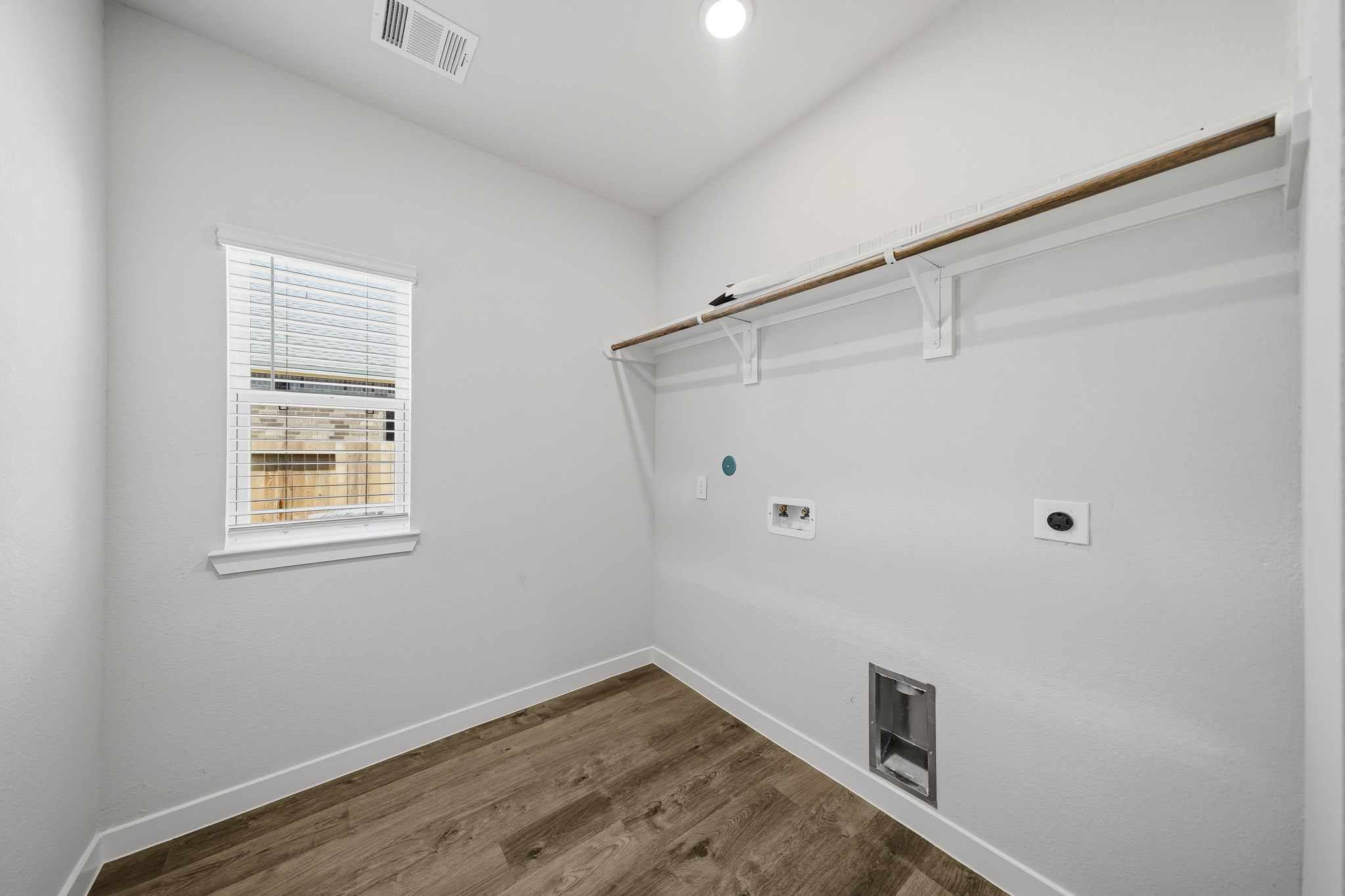 A room with a wood floor and a window.