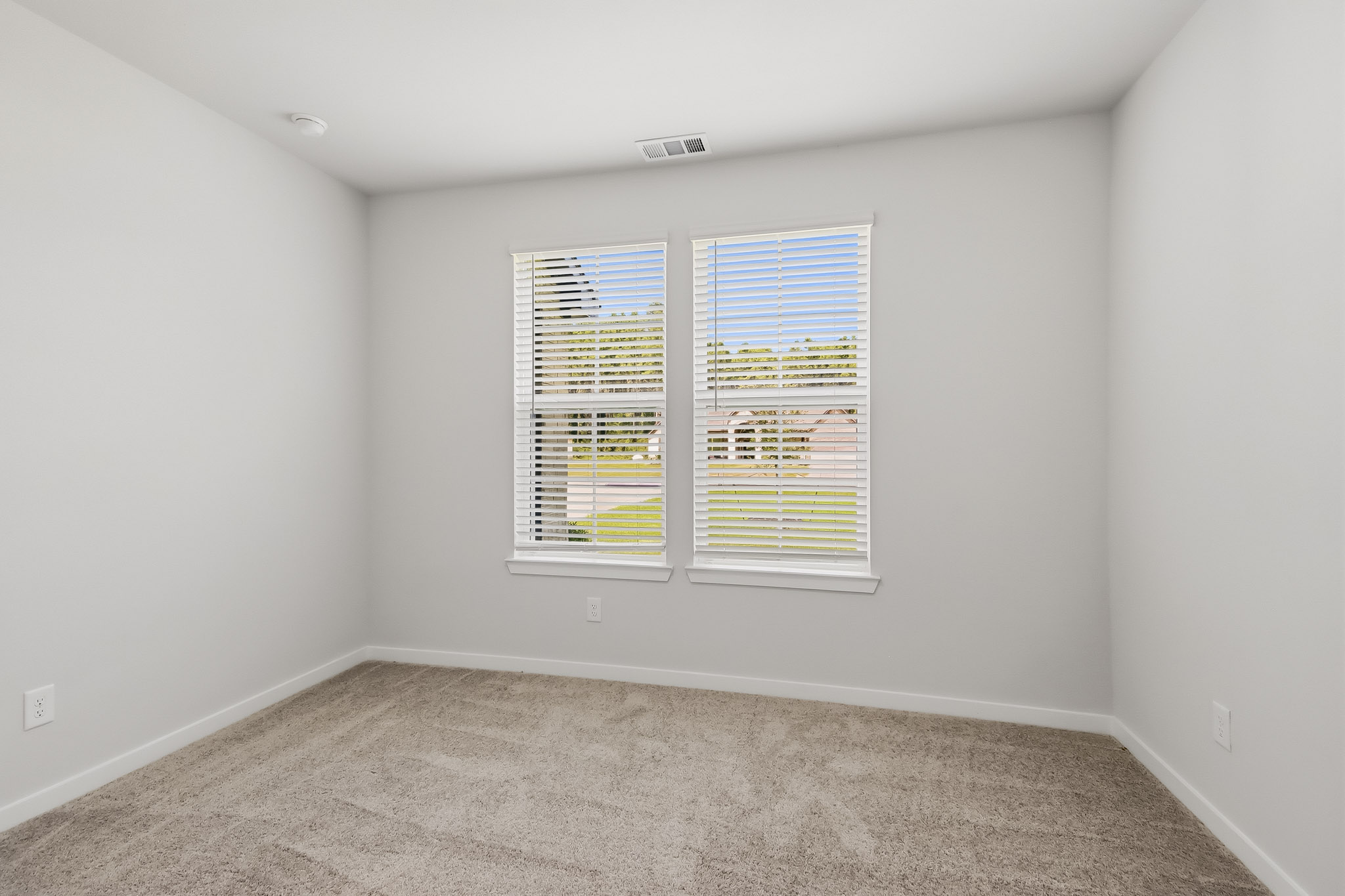 A room with a window and carpet.