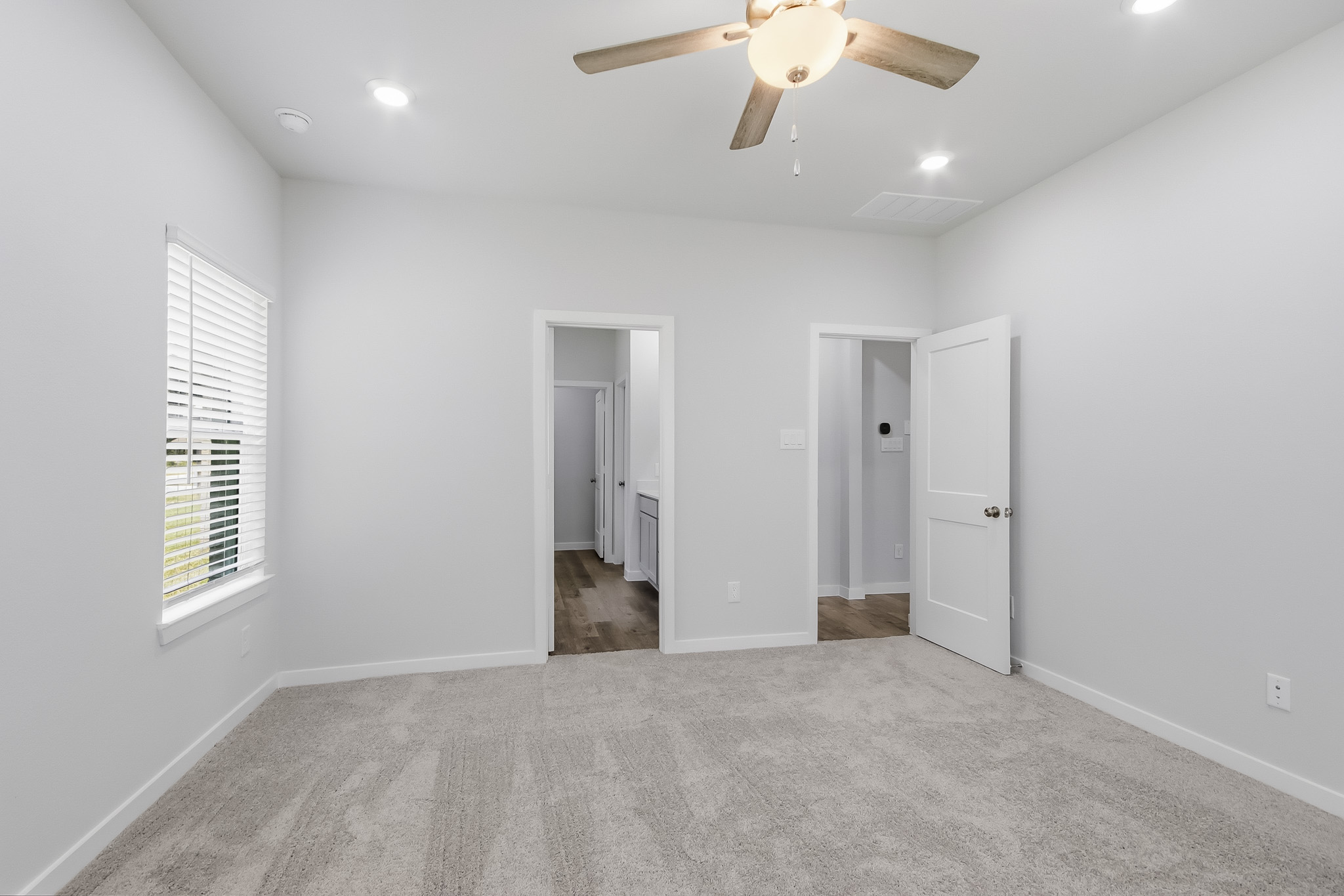 A room with a fan and a carpet.