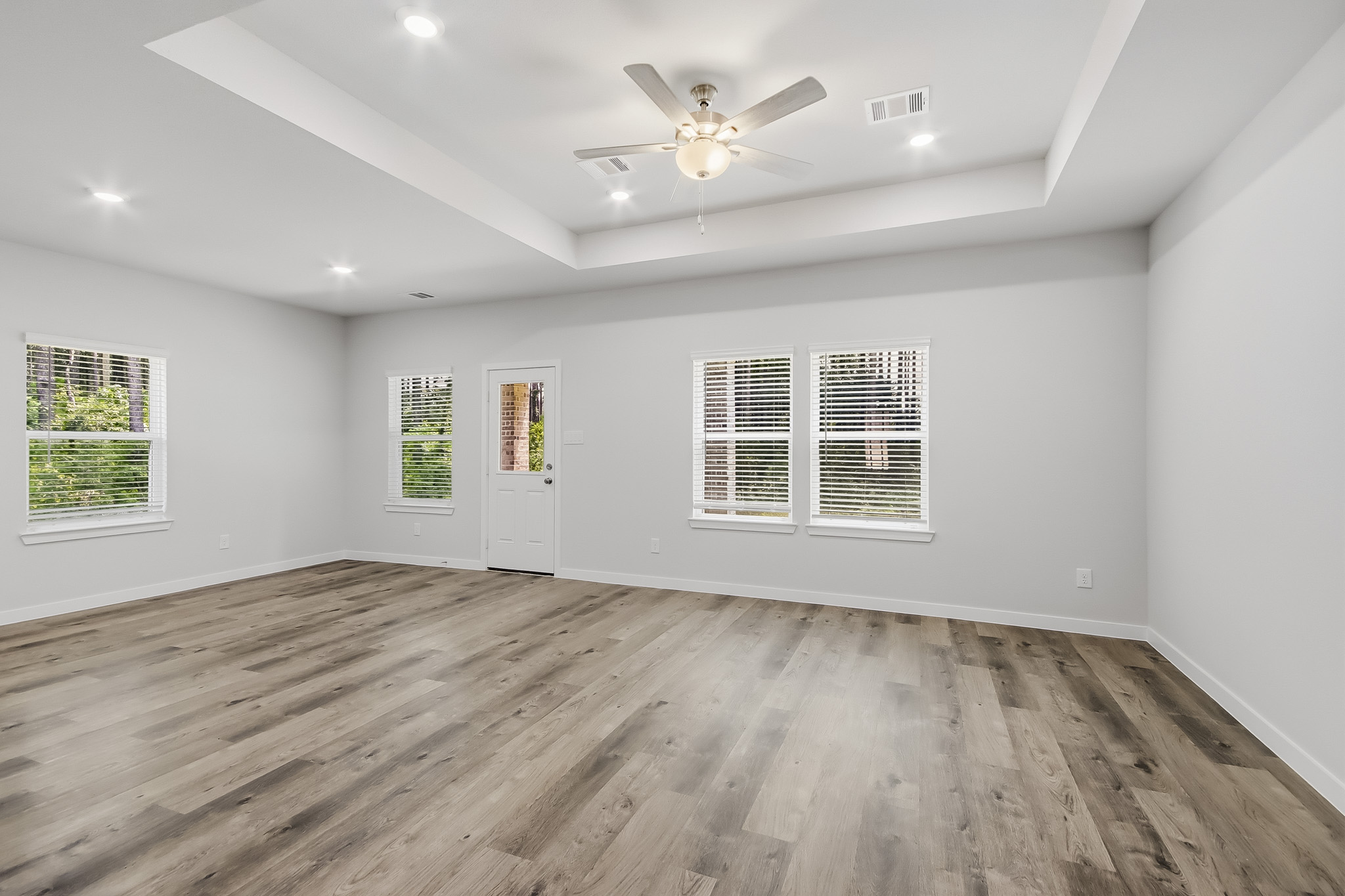 A room with a wood floor and a ceiling fan.