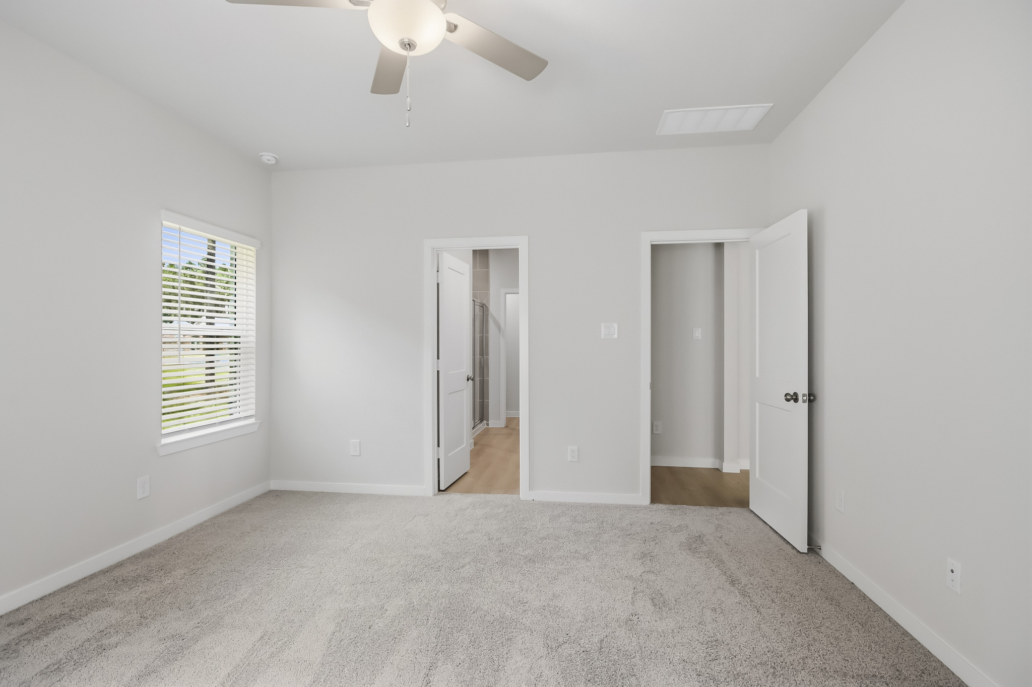 A room with white walls and a ceiling fan.