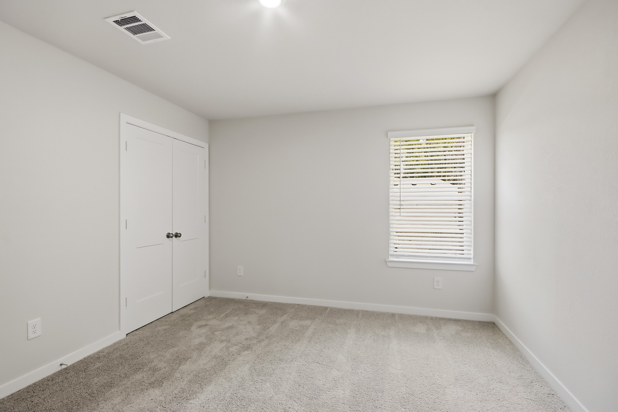 A room with white walls and a window.
