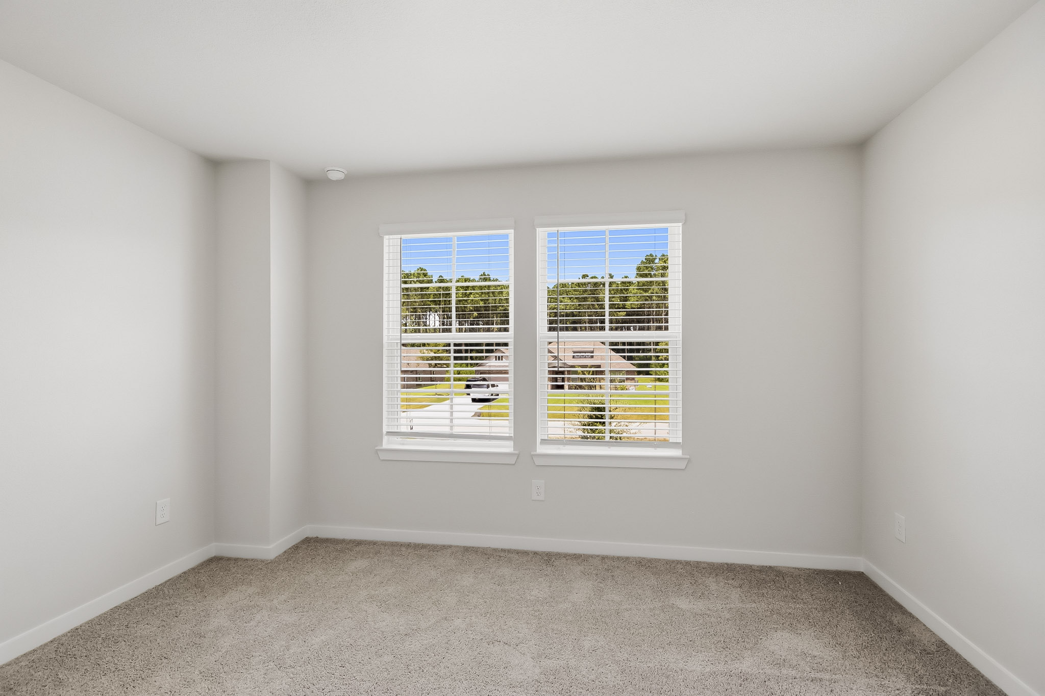 A room with a window and a carpet.