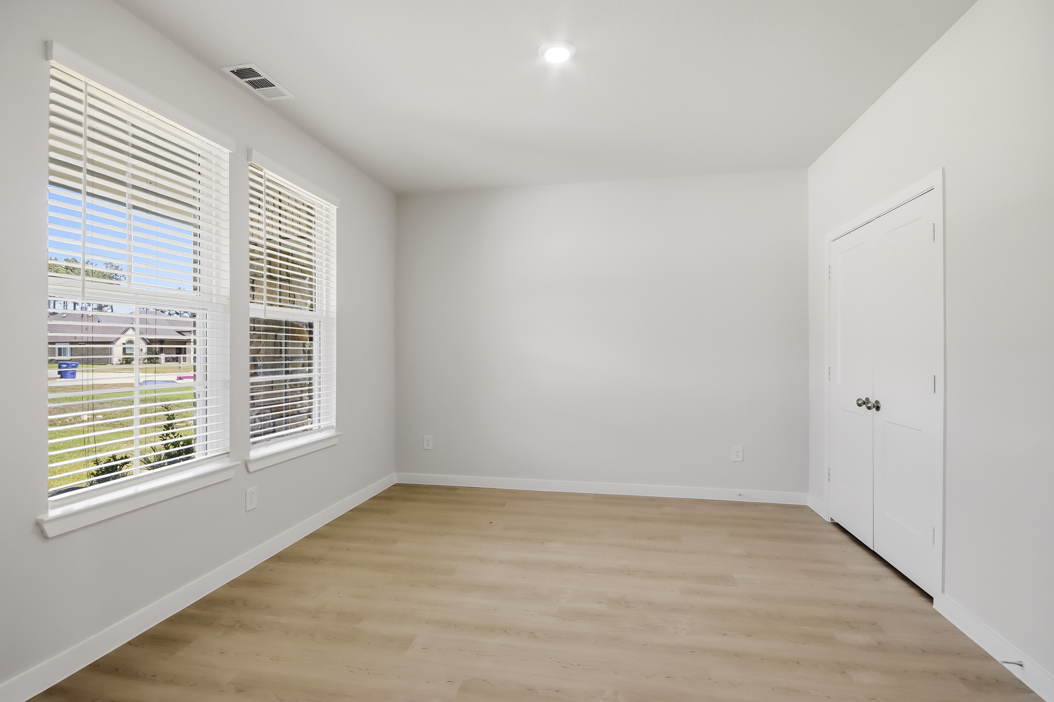 A room with a wood floor and white walls.