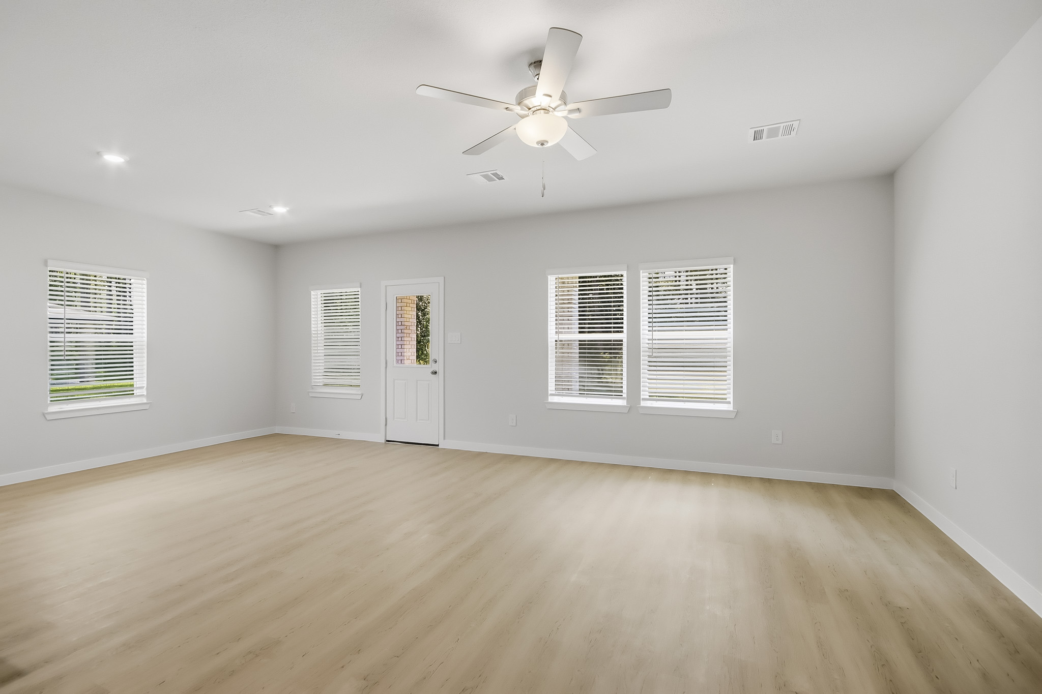 A room with a ceiling fan and a wood floor.