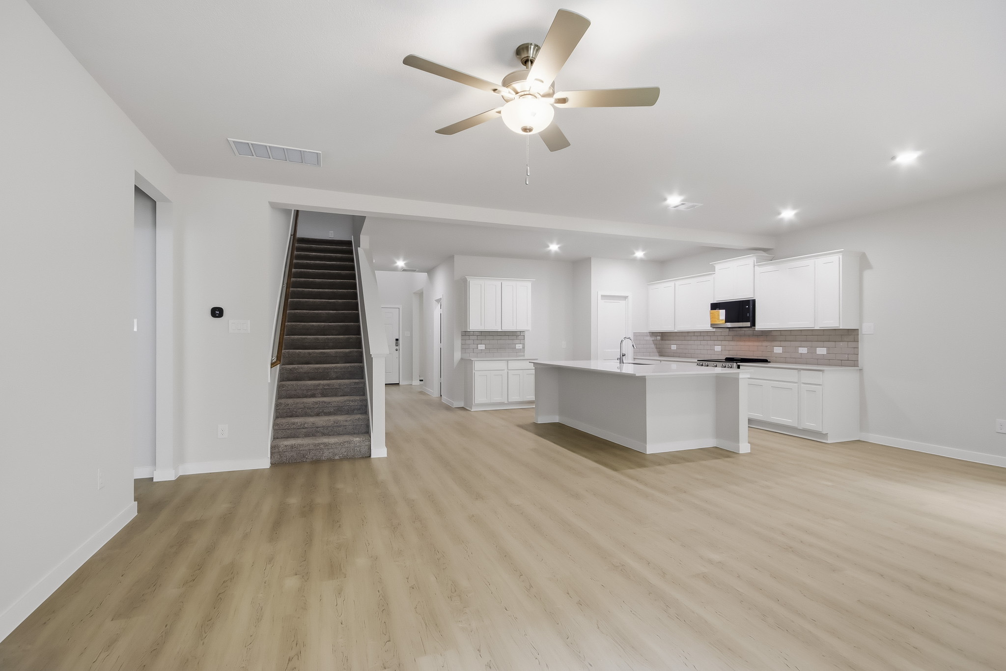 A large kitchen with a wood floor.