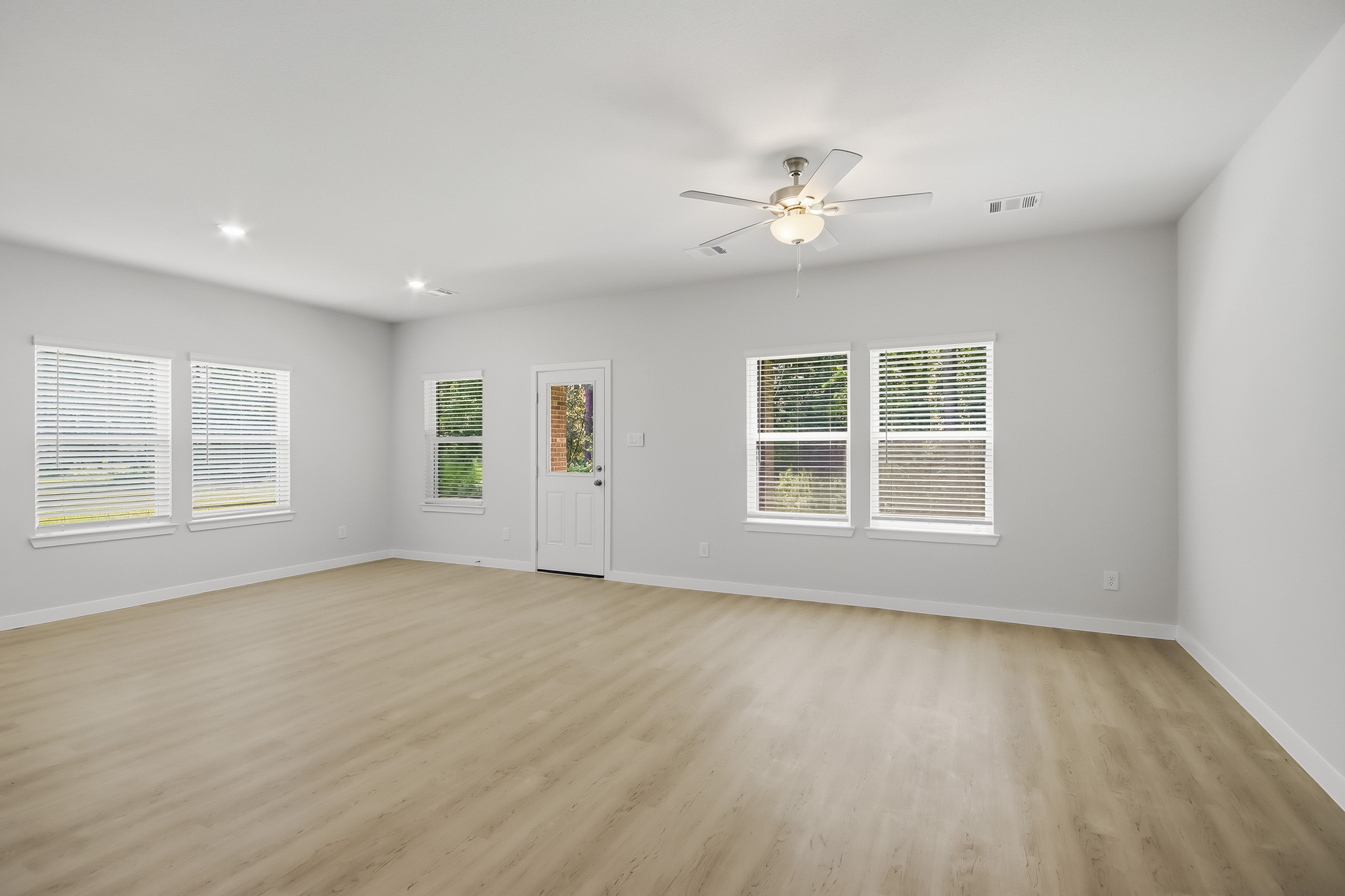 A room with a wood floor and a ceiling fan.