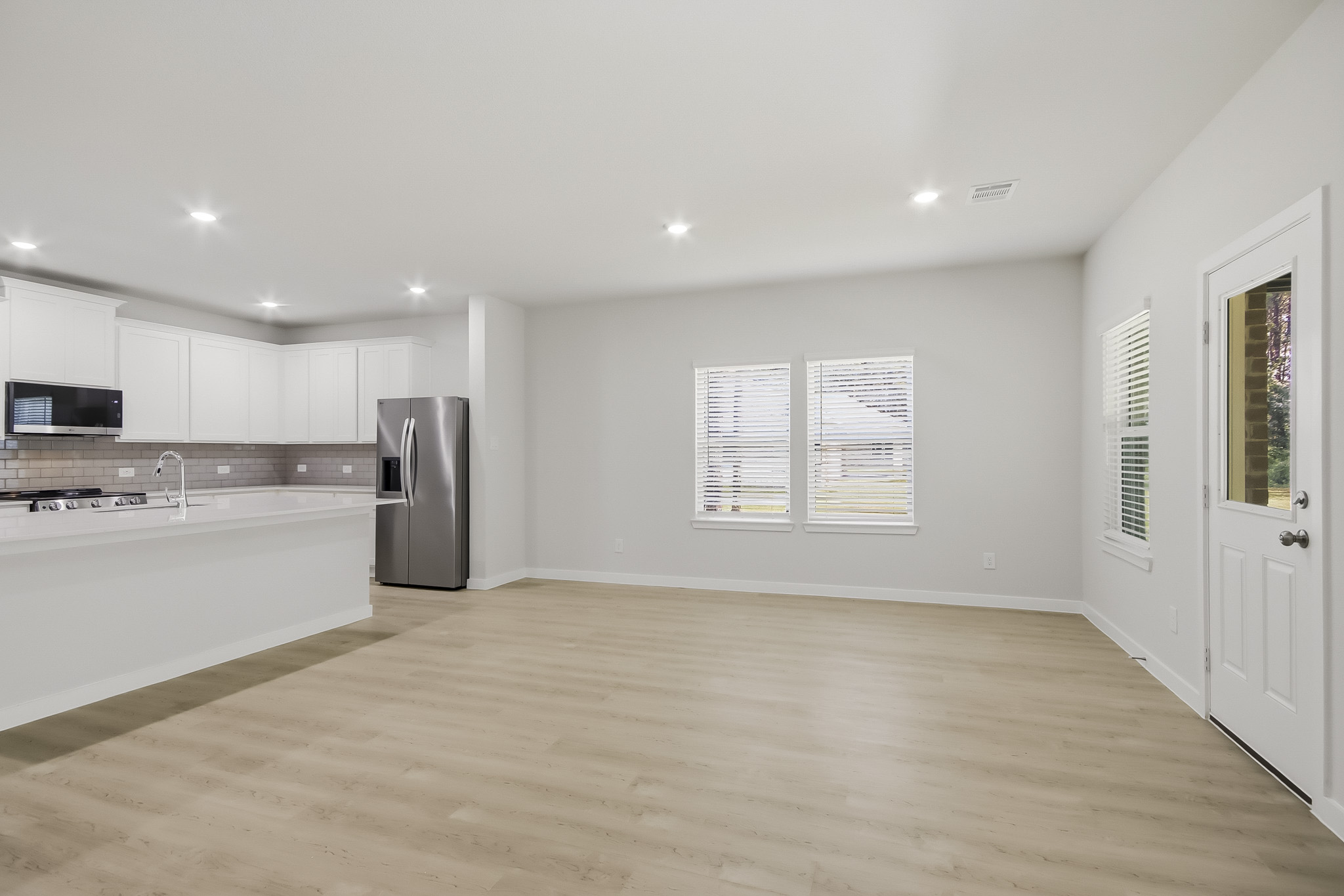 A large kitchen with a wood floor.