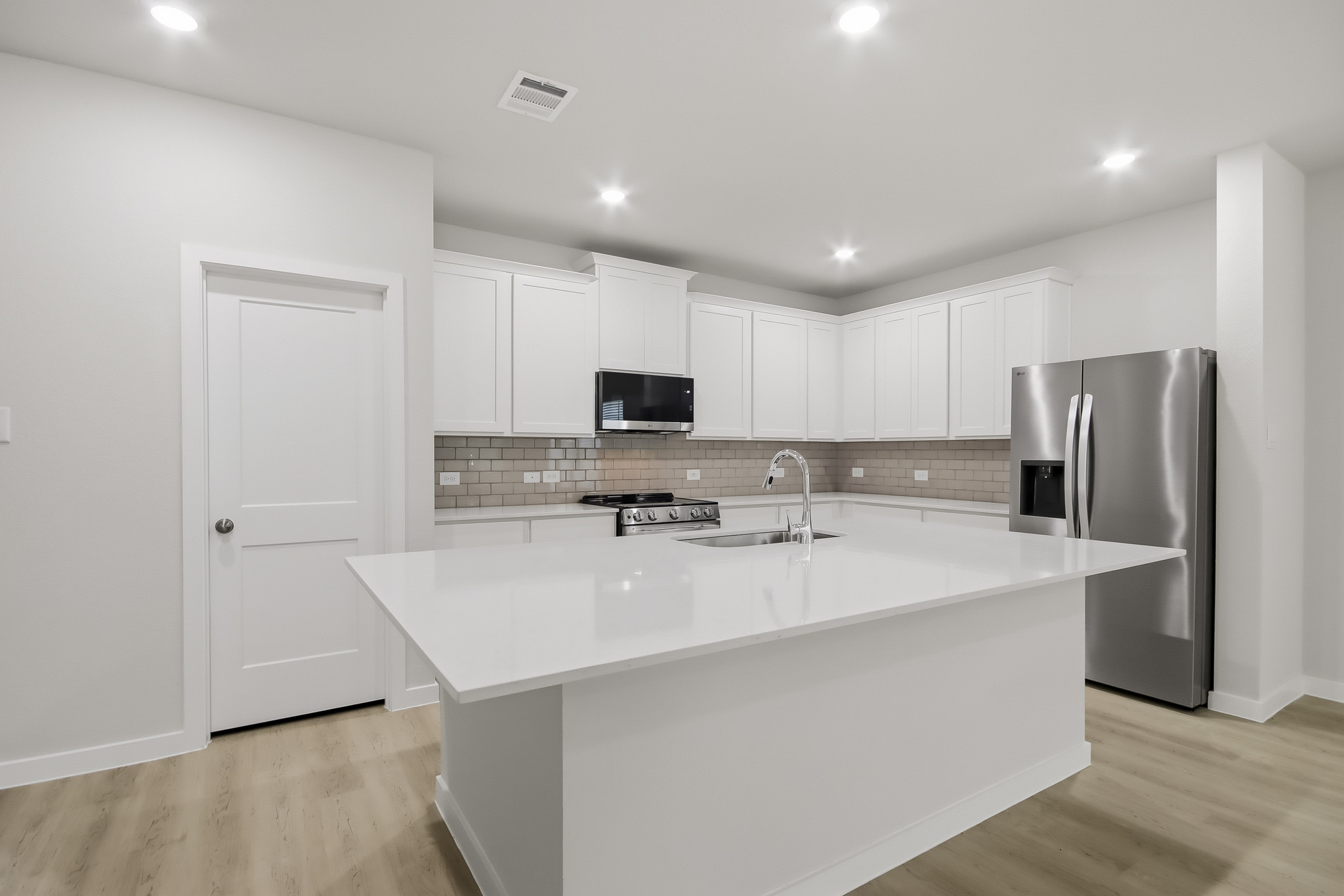 A kitchen with white cabinets.
