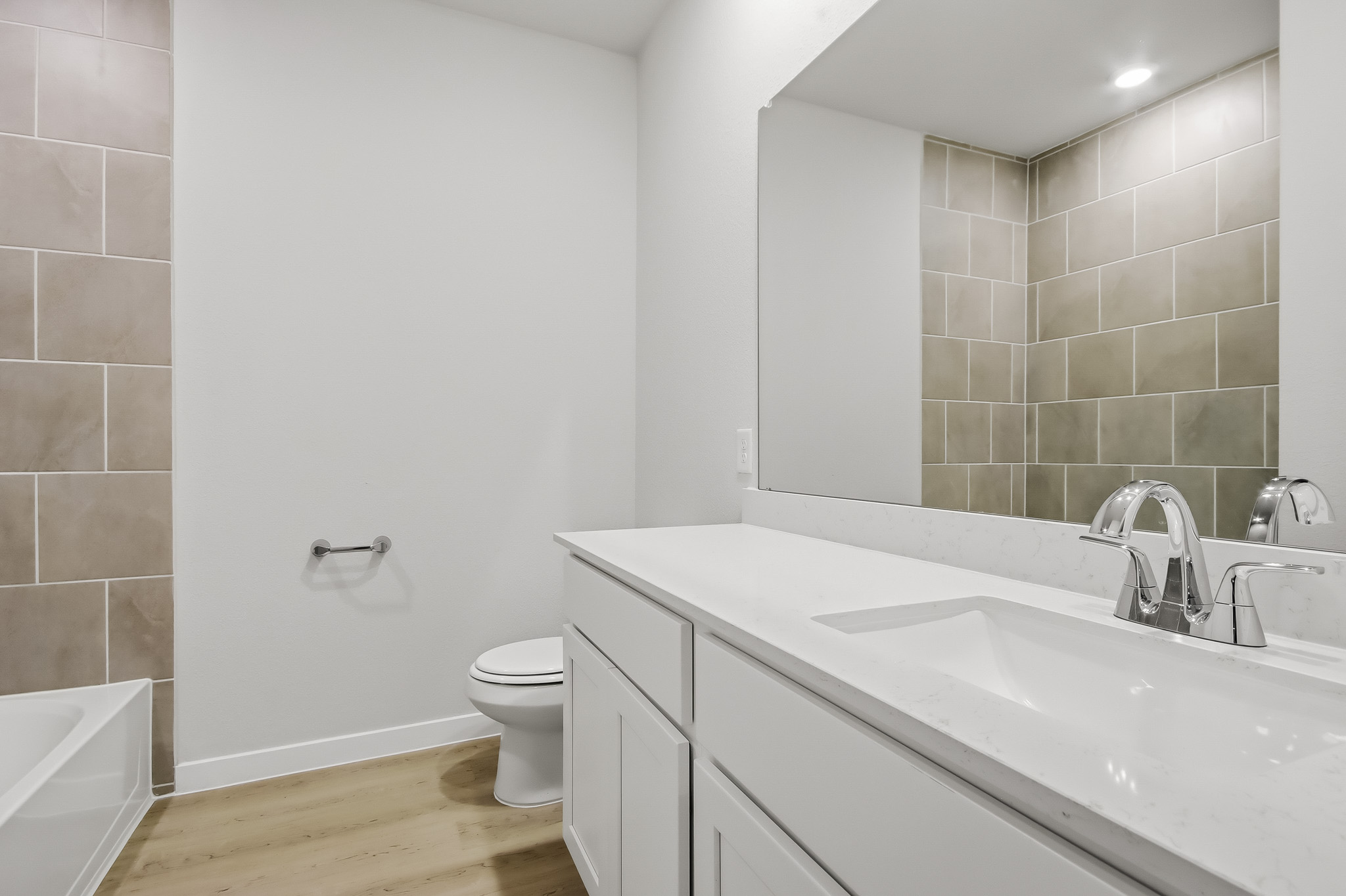 A bathroom with a tub sink and toilet.