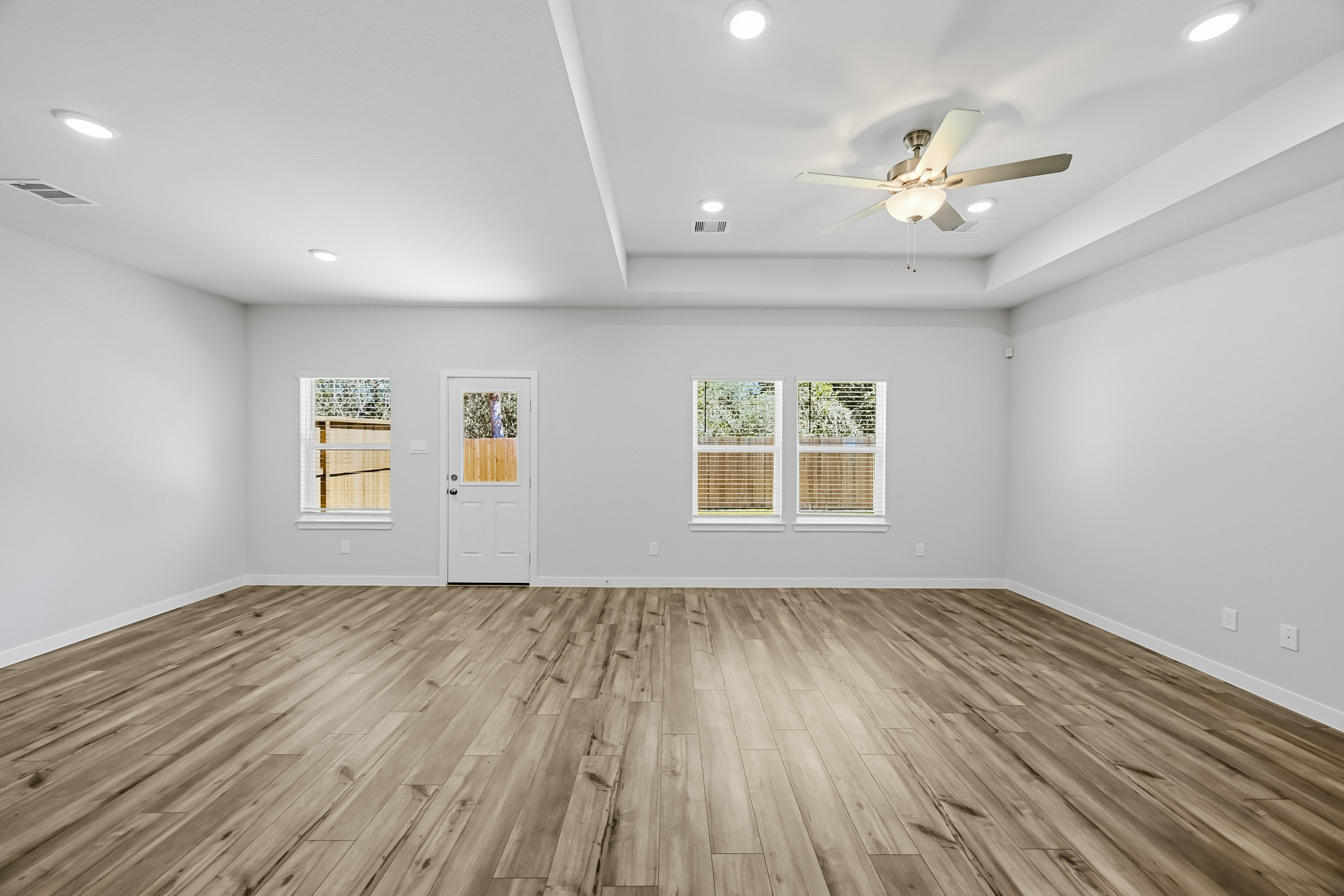 A room with a wood floor and a ceiling fan.