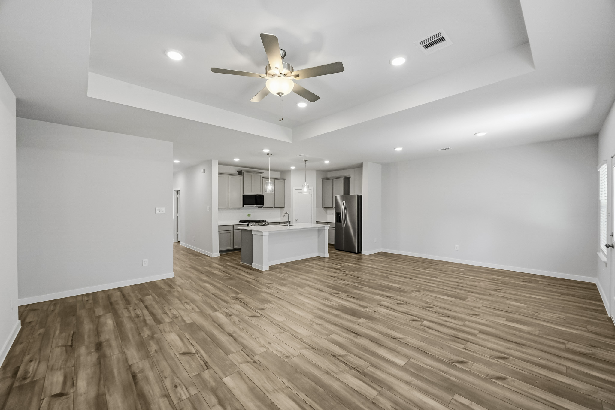 A large kitchen with a wood floor.
