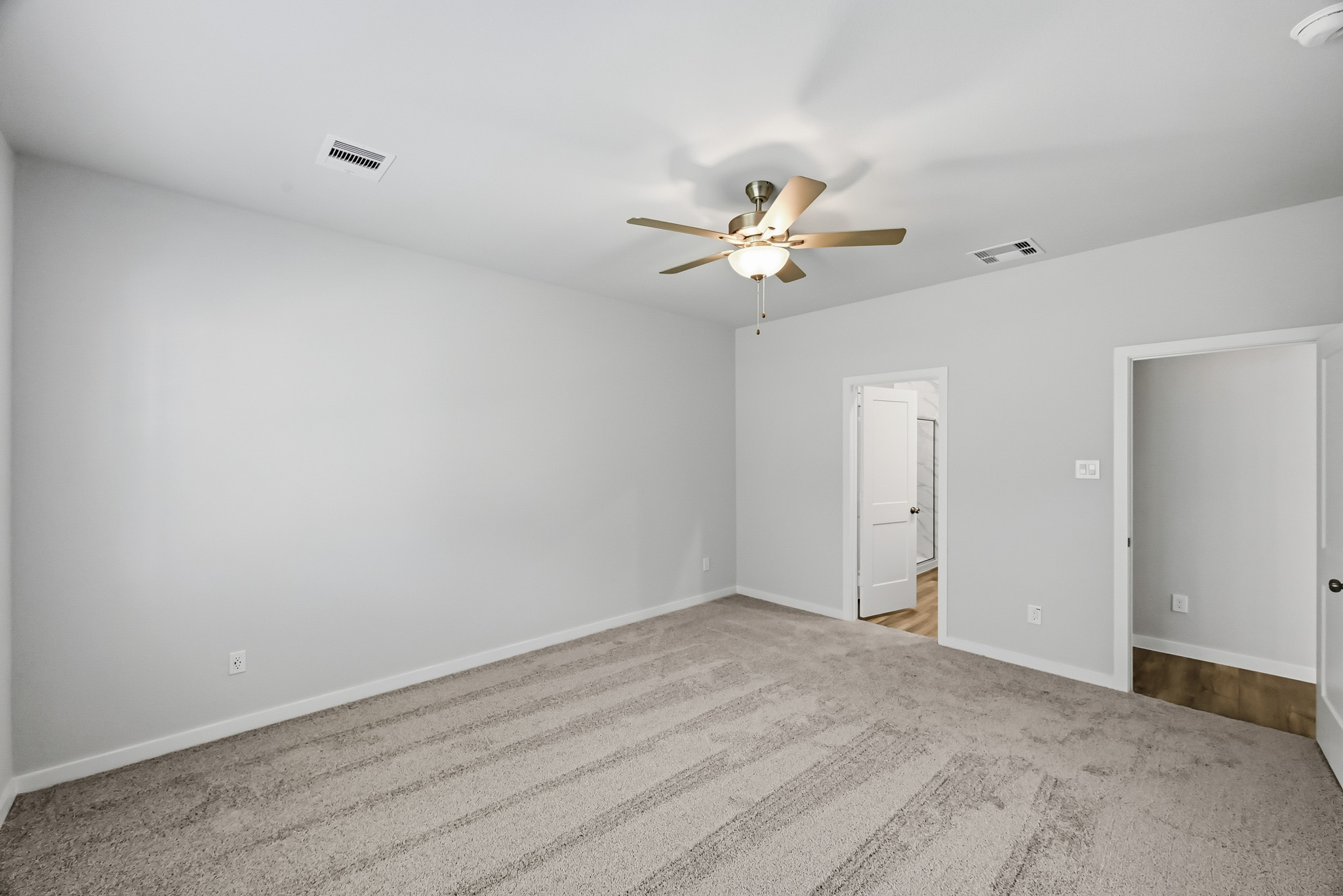 A room with a ceiling fan and a door.