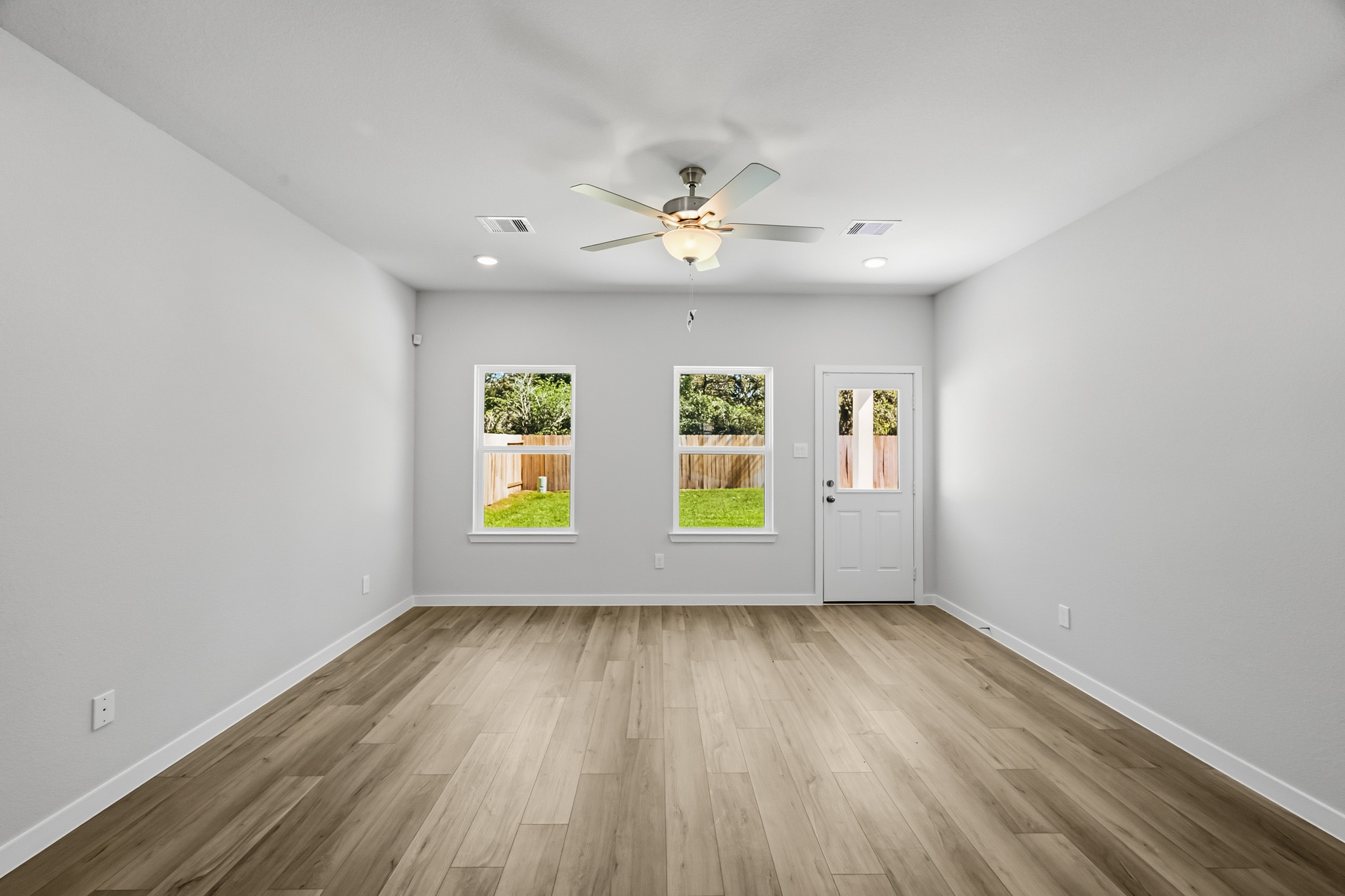 A room with a wood floor and a ceiling fan.