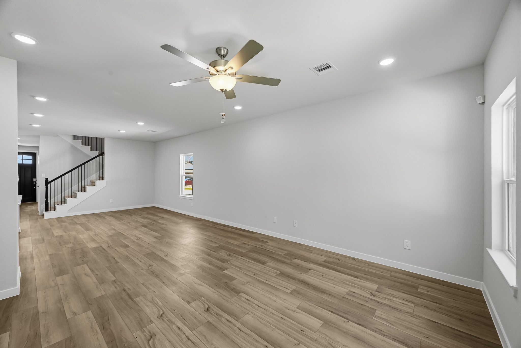A room with a wood floor and a ceiling fan.