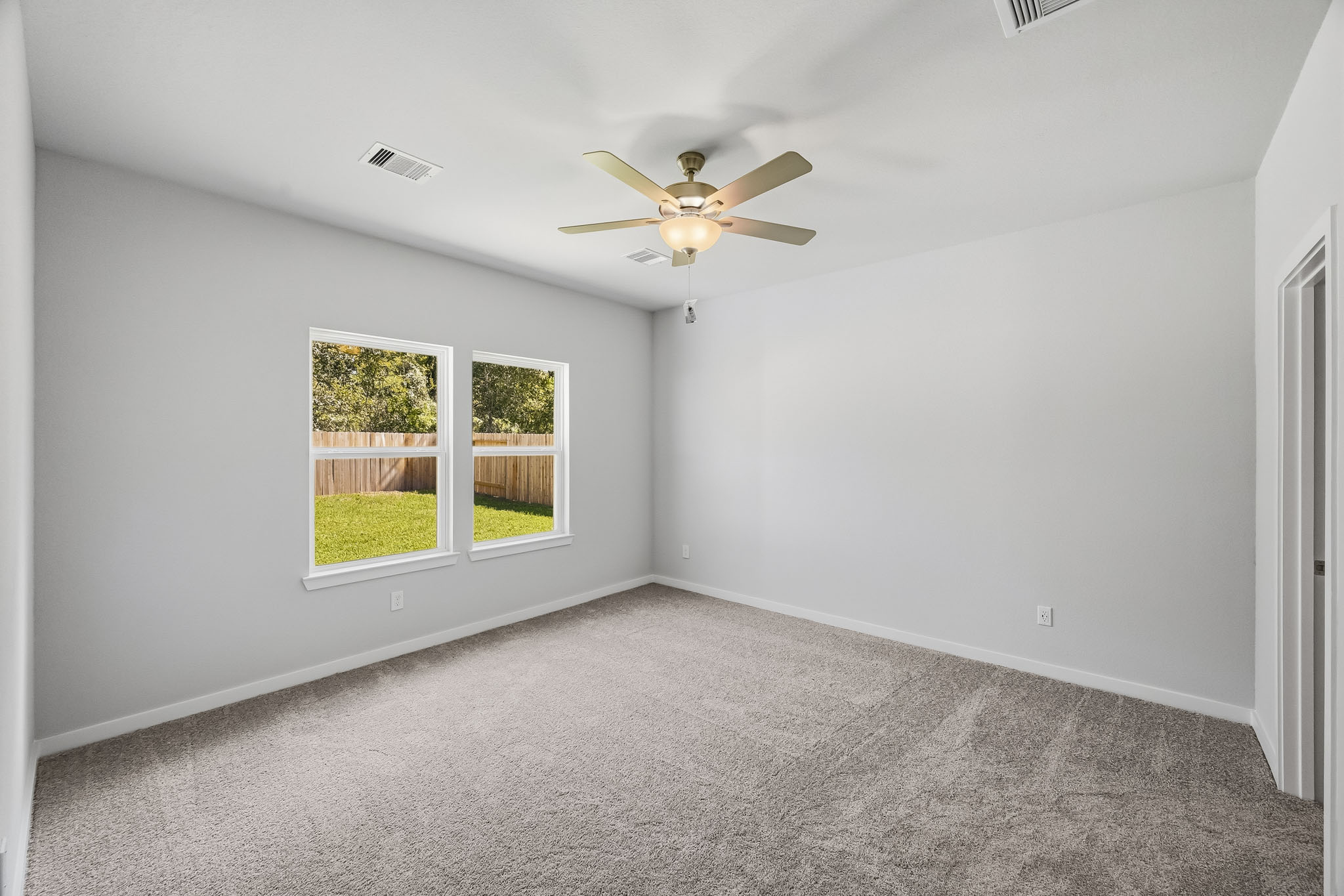 A room with a ceiling fan and a window.