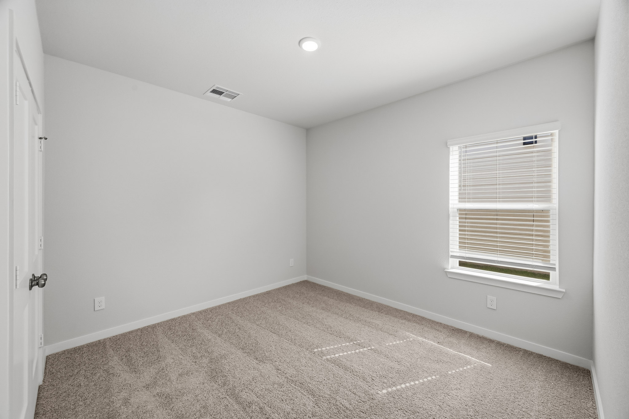 A room with a carpet and a window.