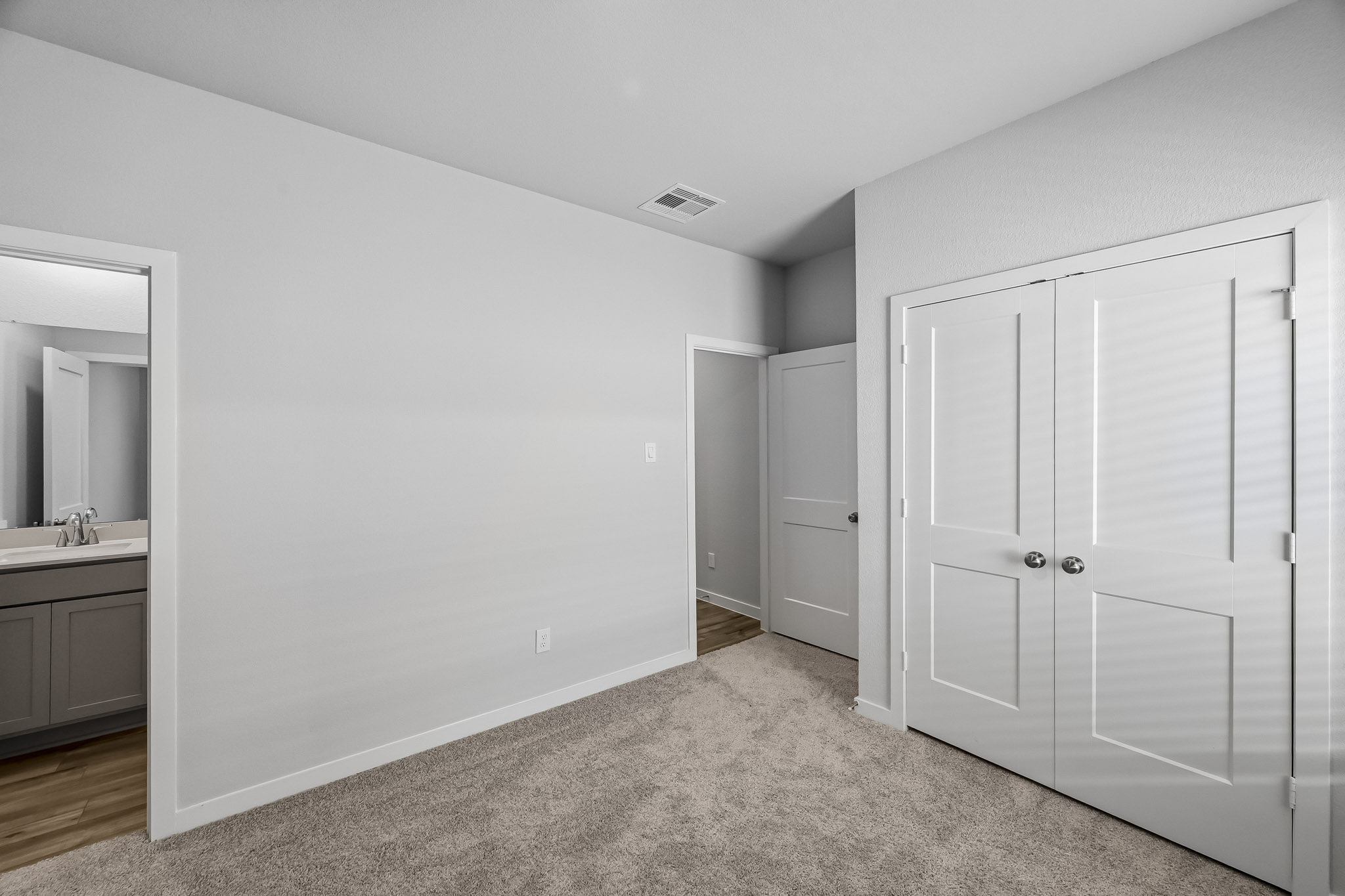 A bathroom with white cabinets.