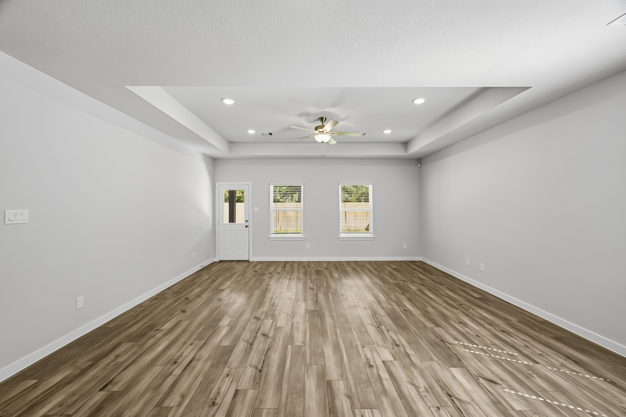 A room with a wood floor and a ceiling fan.