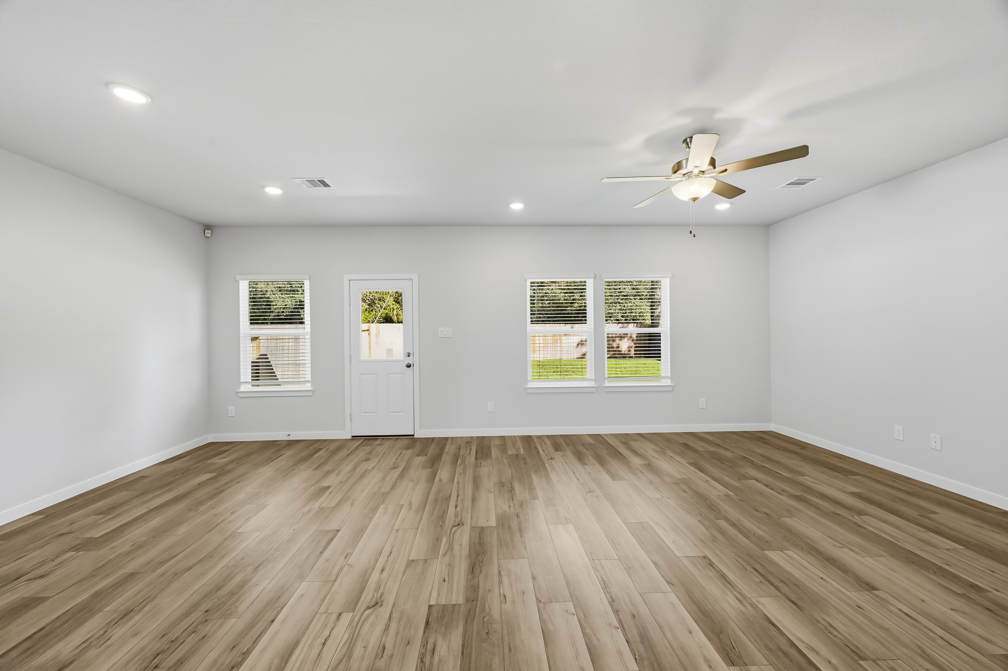 A room with a wood floor and a ceiling fan.