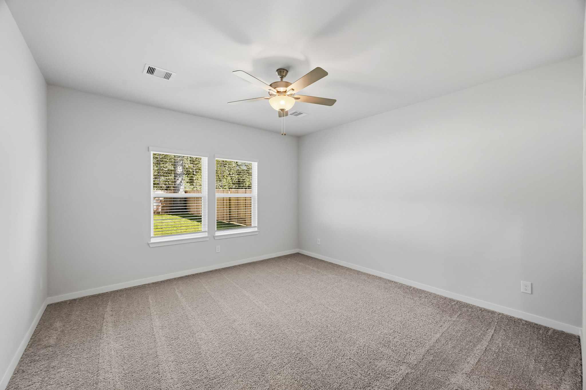 A room with a ceiling fan and a window.