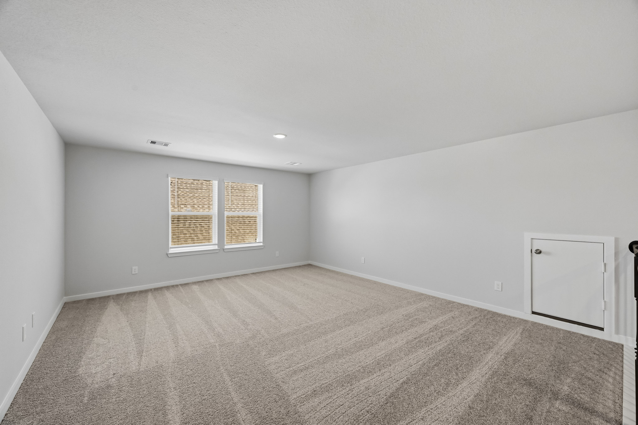 A room with a carpet and windows.