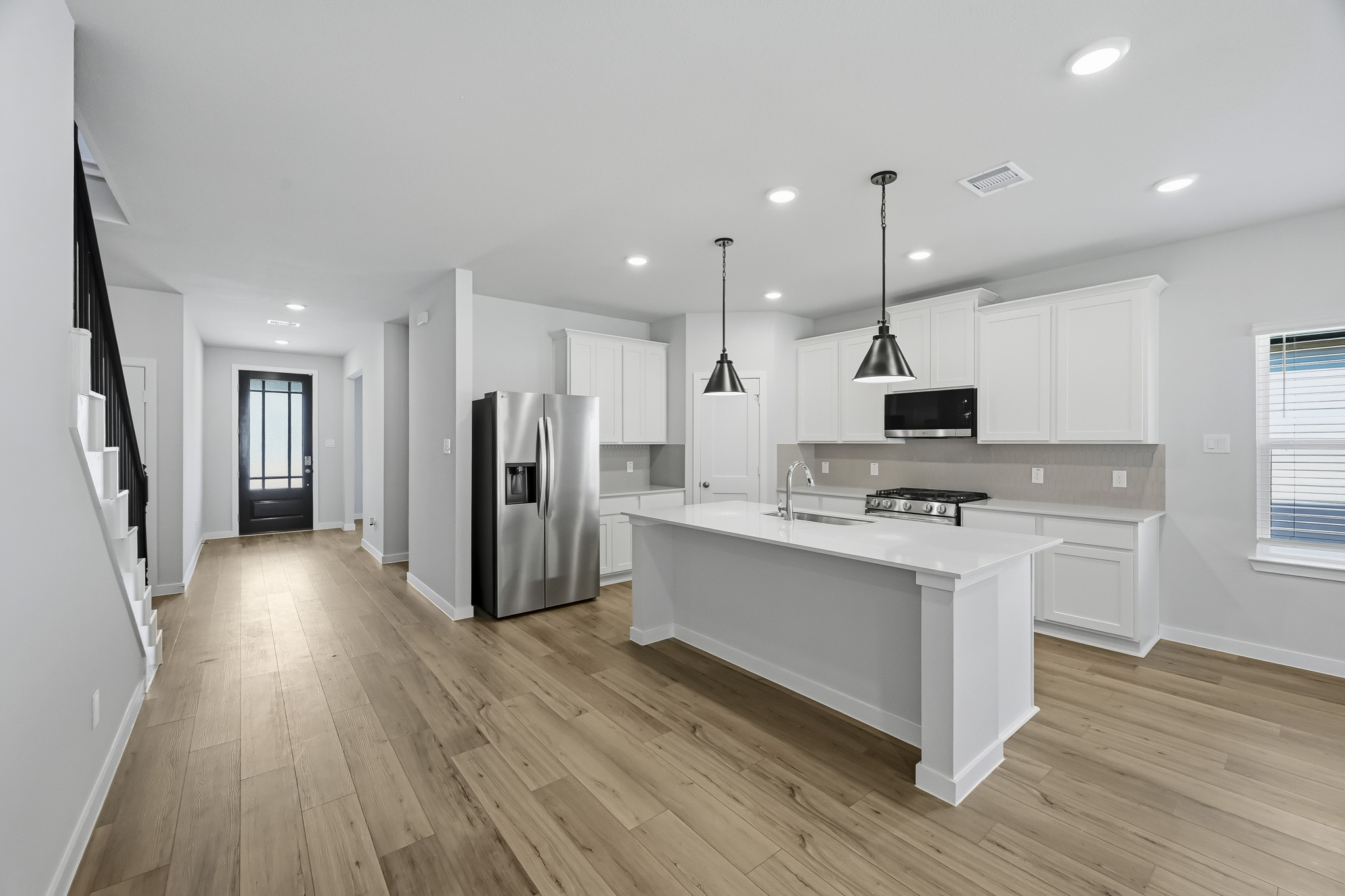 A kitchen with white cabinets.