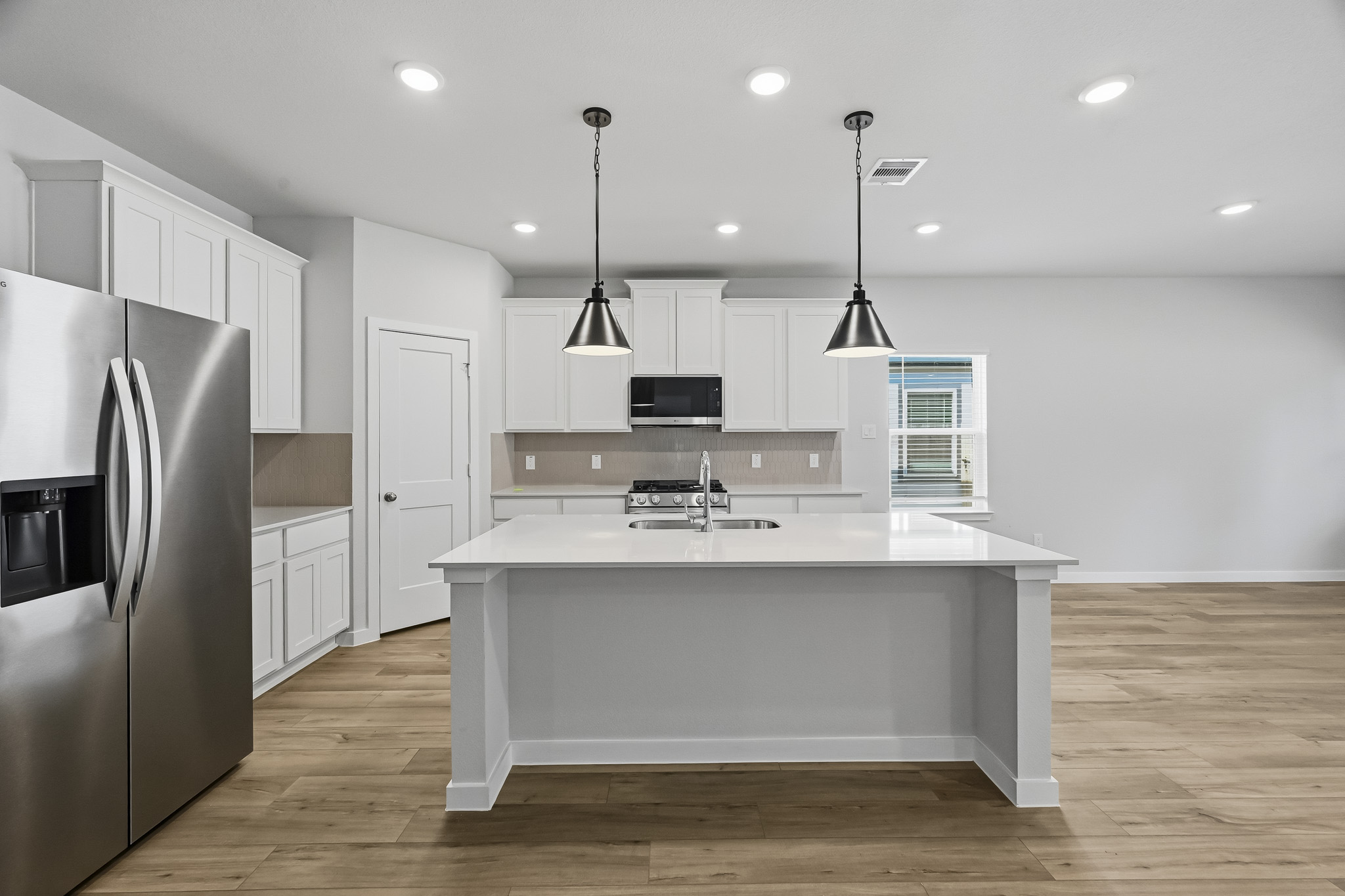 A kitchen with white cabinets.