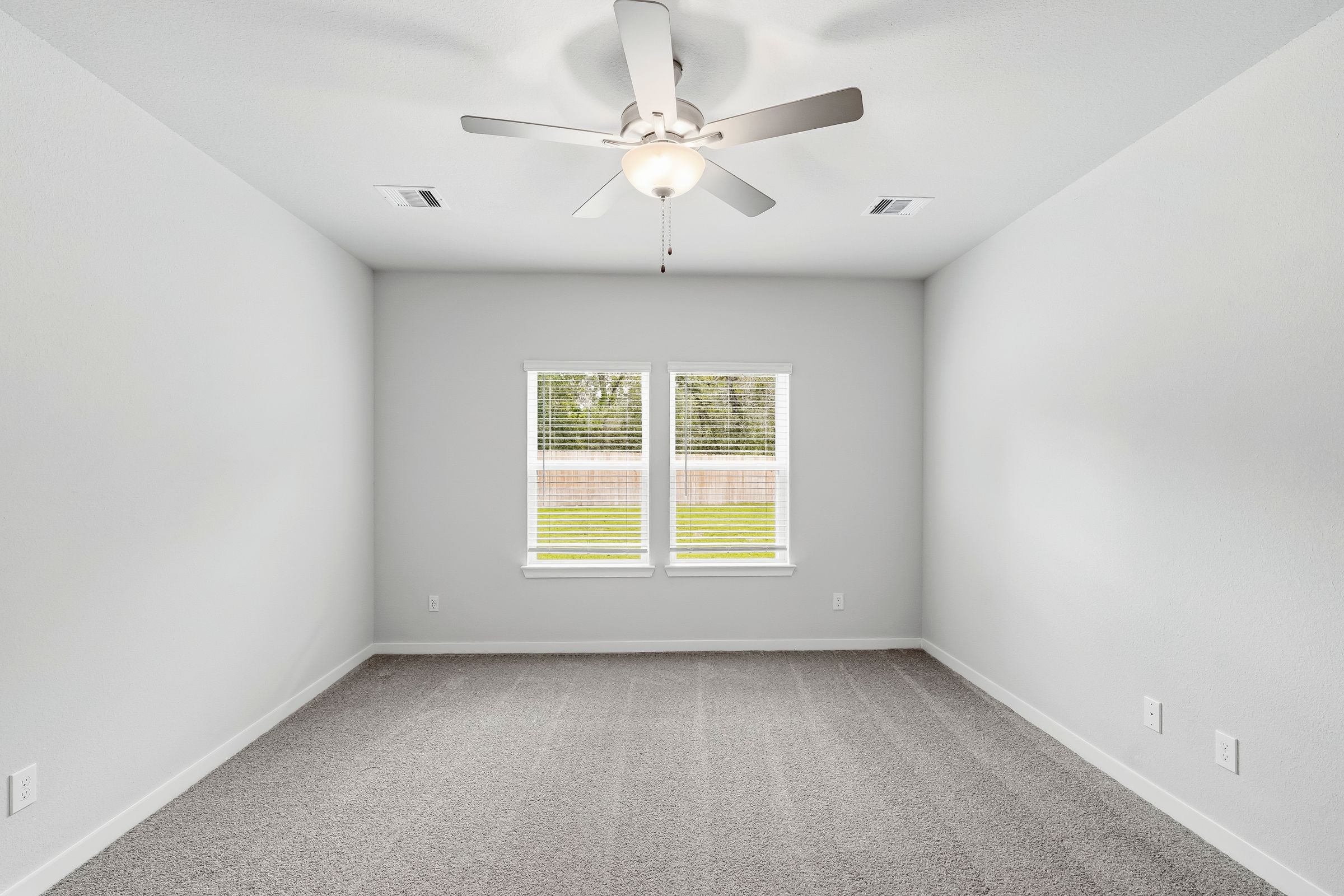 A room with a ceiling fan and a window.
