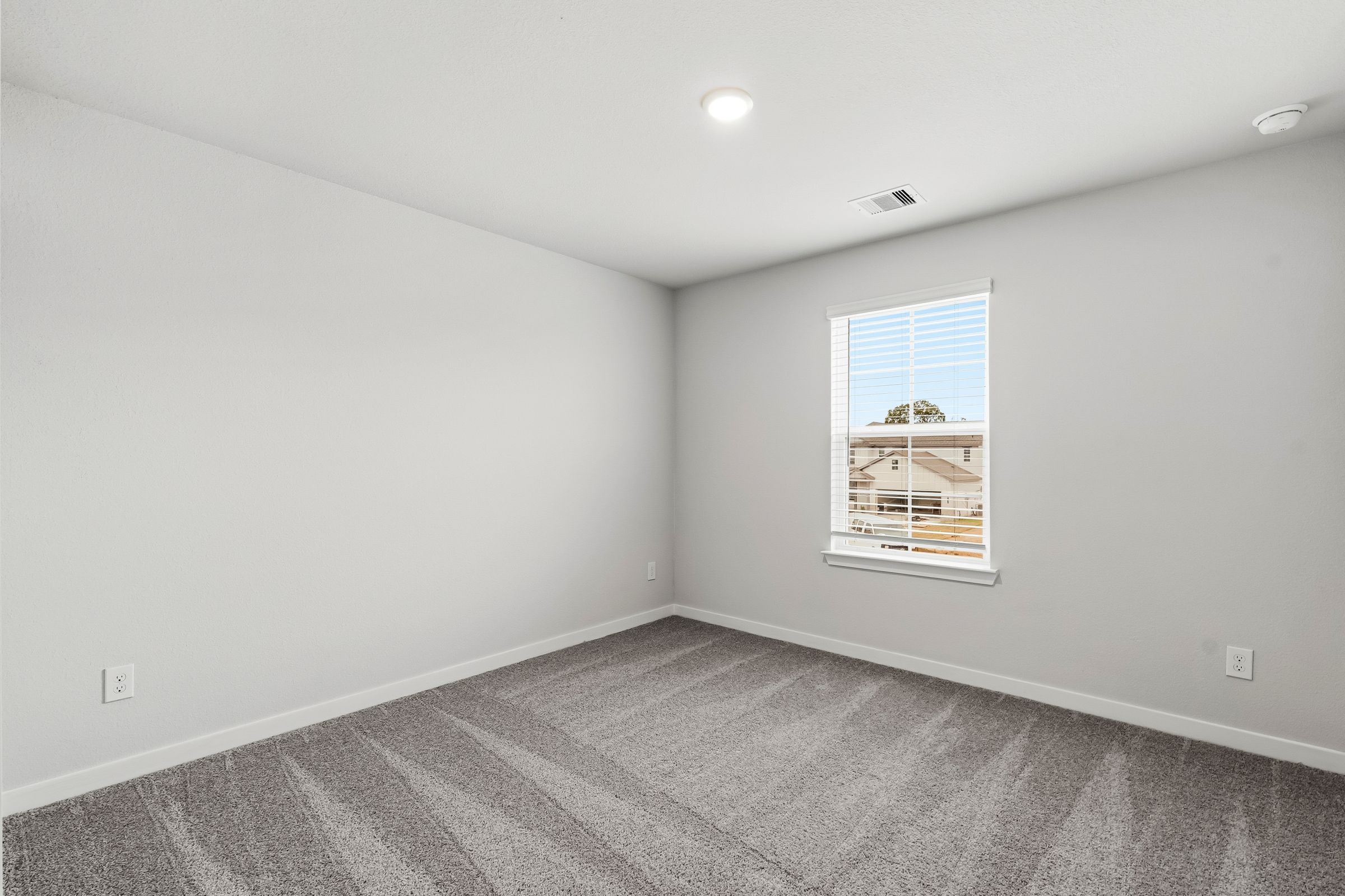 A room with a window and a carpet.