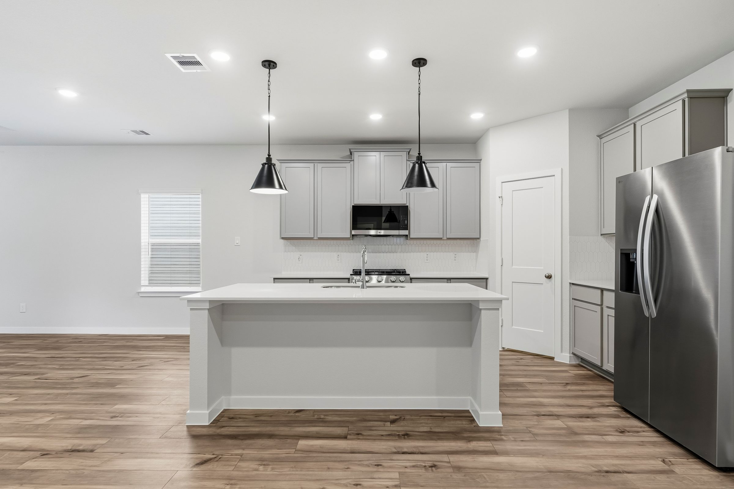 A kitchen with white cabinets.