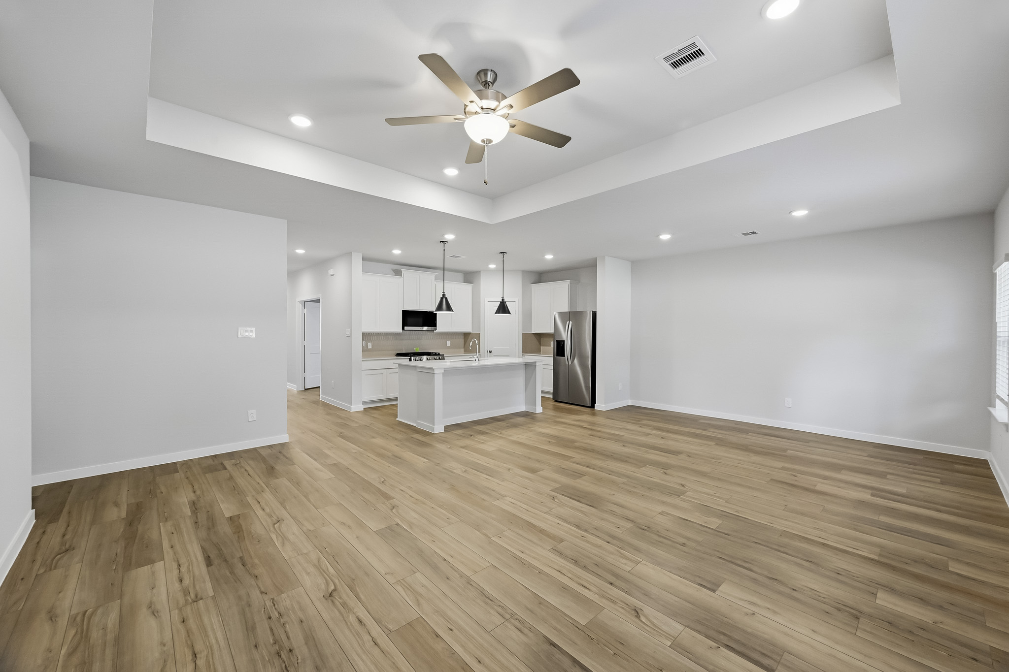 A large kitchen with a wood floor.