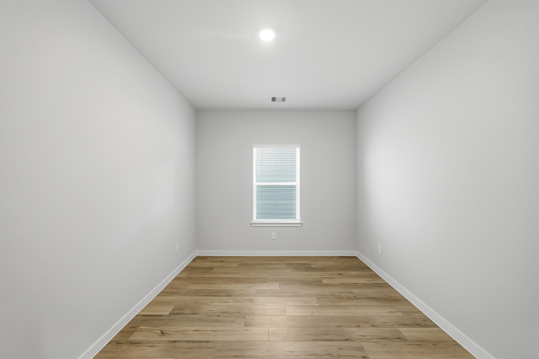 A room with a wood floor and white walls.