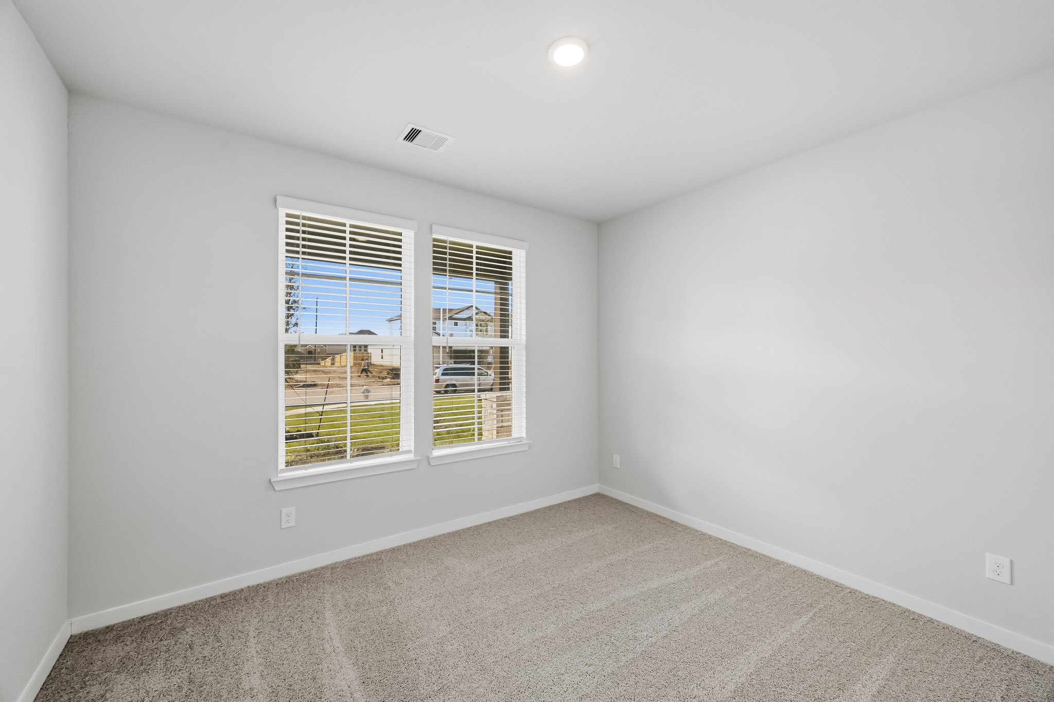 A room with a window and a white wall.