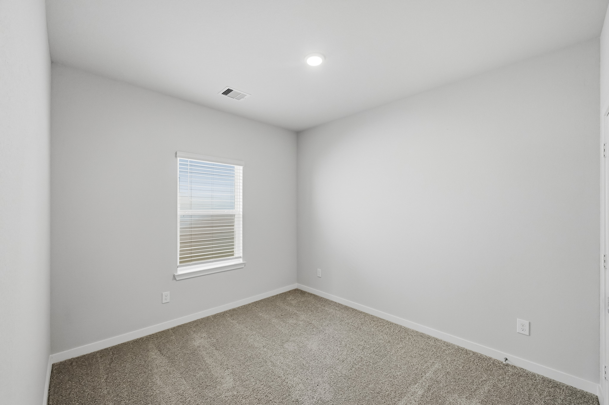 A room with a carpet and a window.
