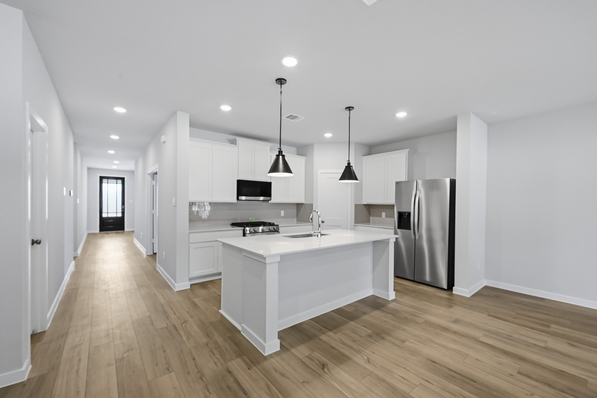 A kitchen with white cabinets.