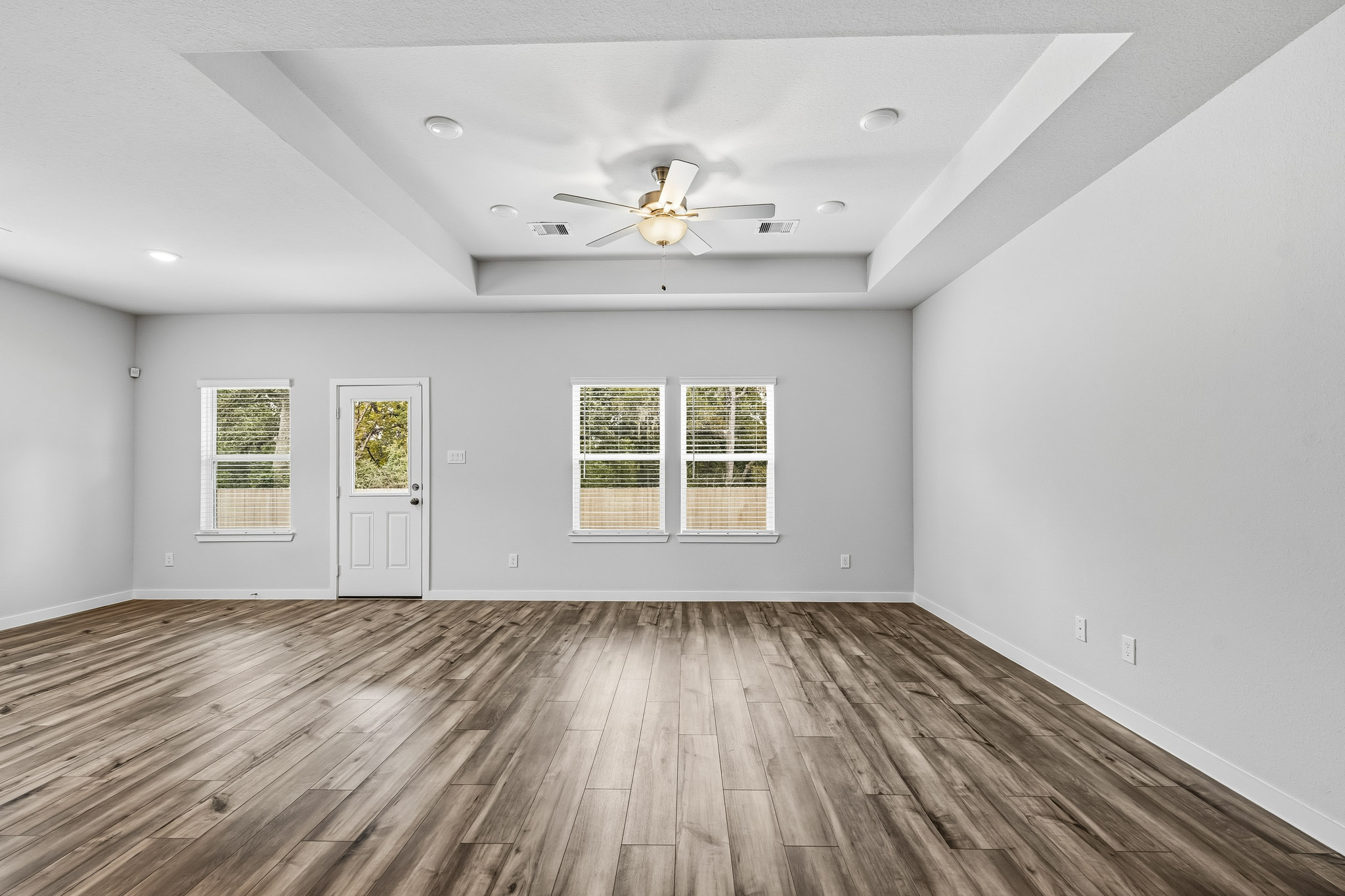 A room with a wood floor and a ceiling fan.