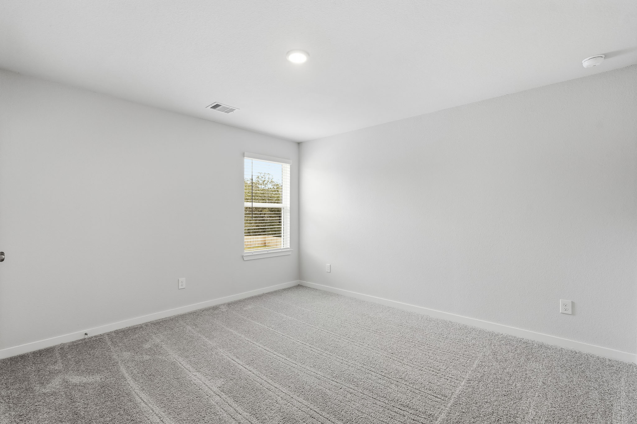 A room with a window and a carpet.