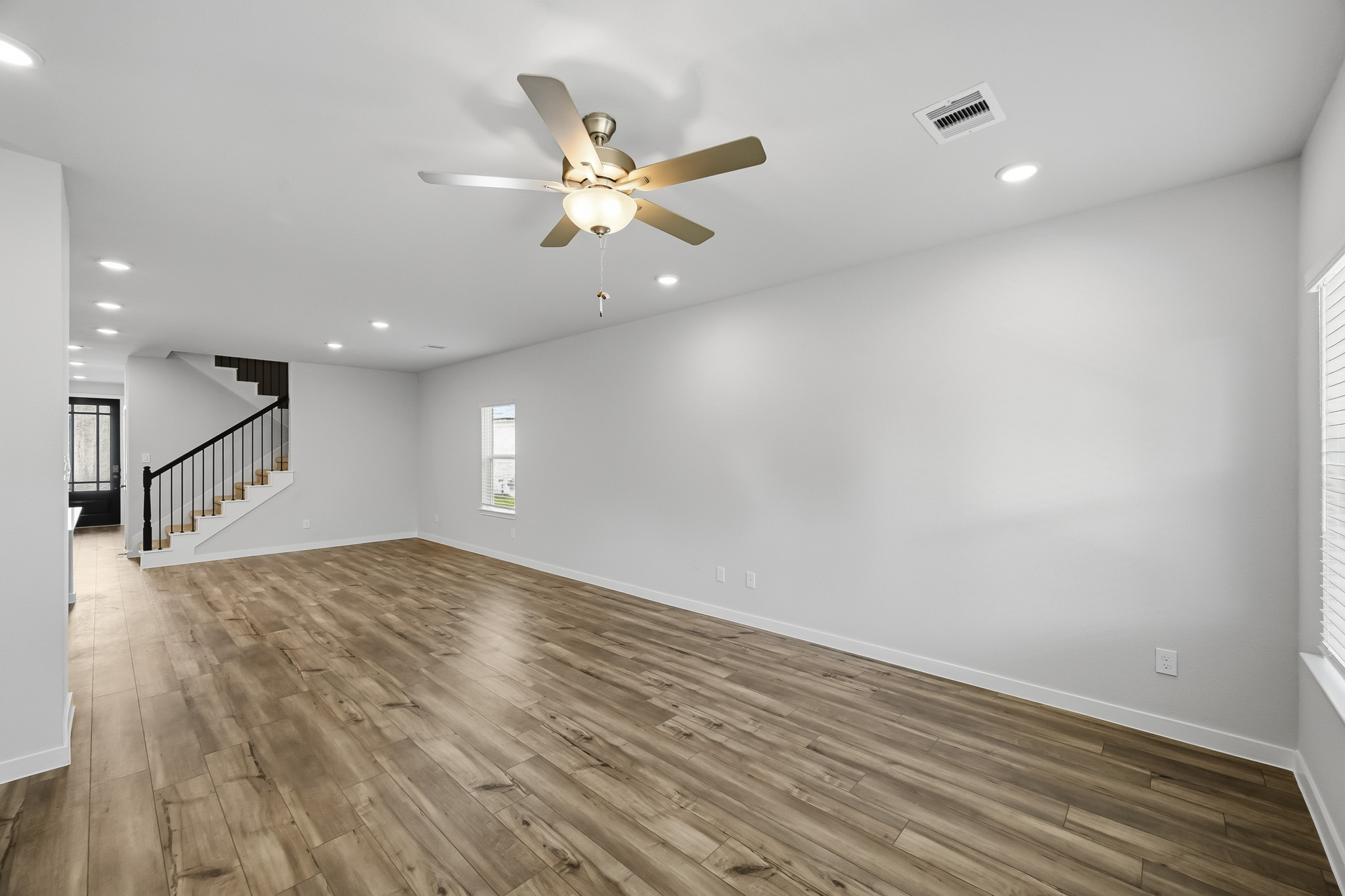 A room with a wood floor and a ceiling fan.