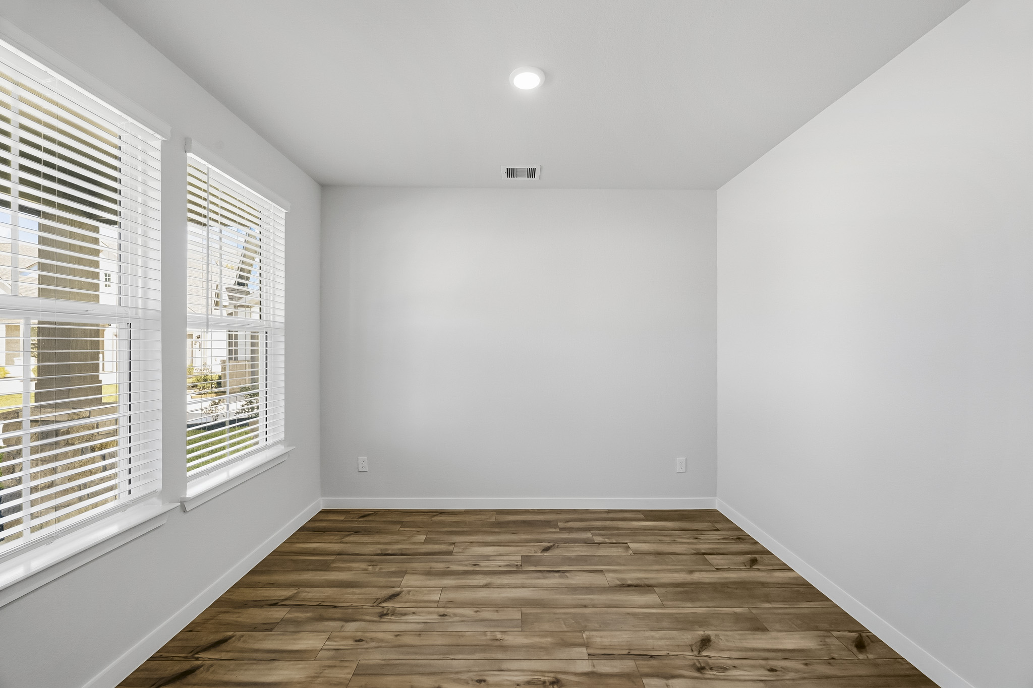 A room with a wood floor and windows.