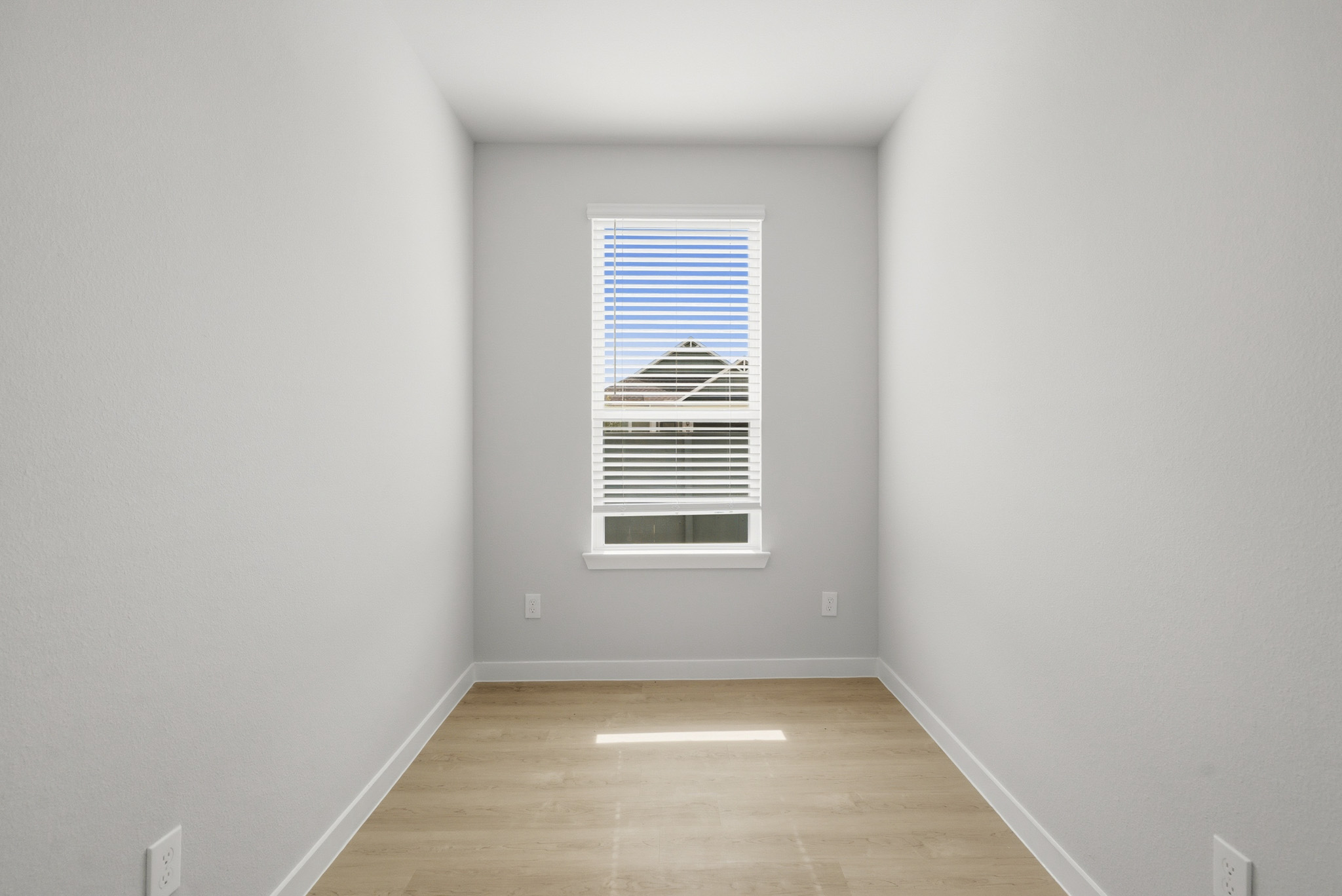 A room with a wood floor and a window.