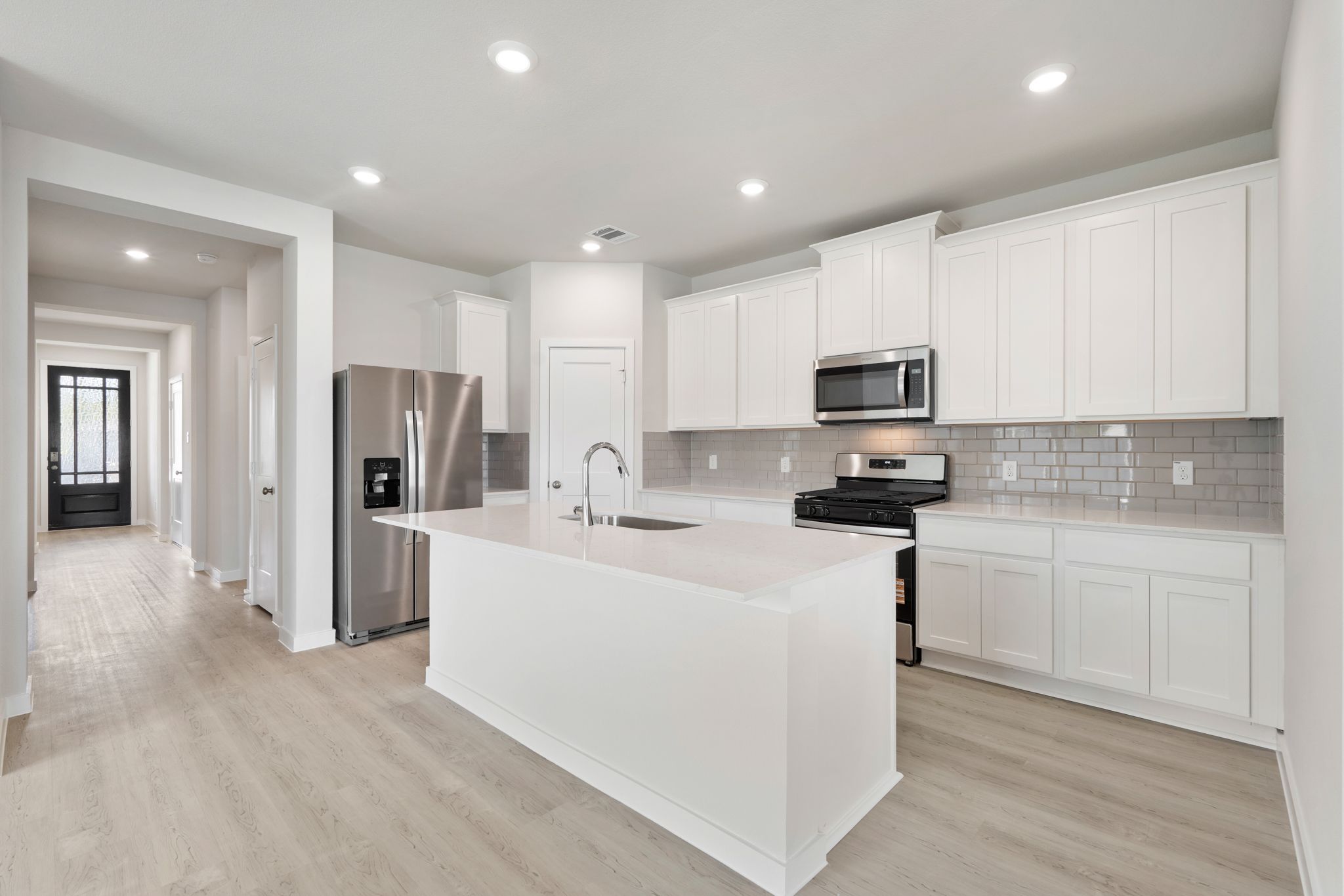 A kitchen with white cabinets.