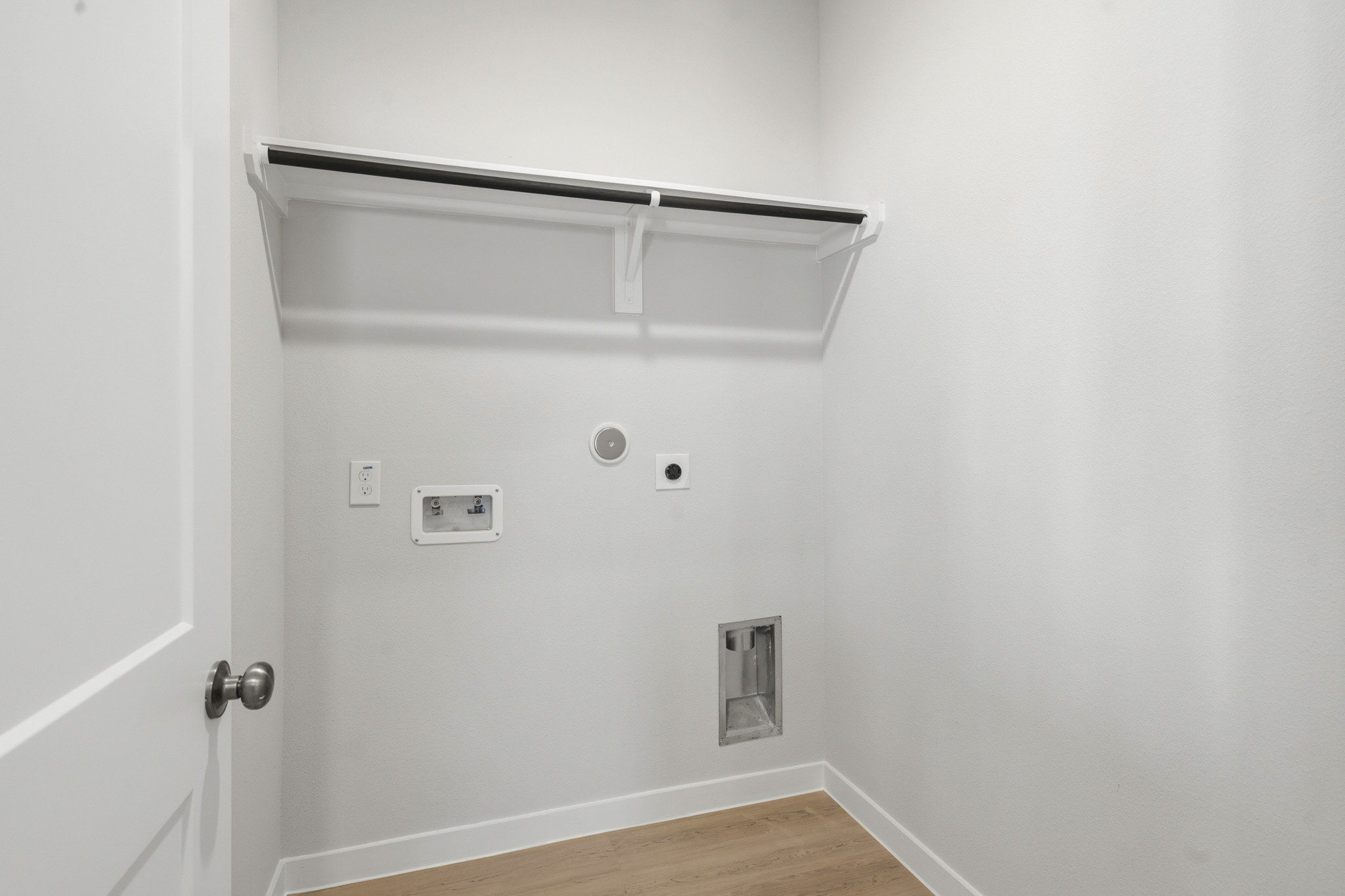 A white wall with a light switch.