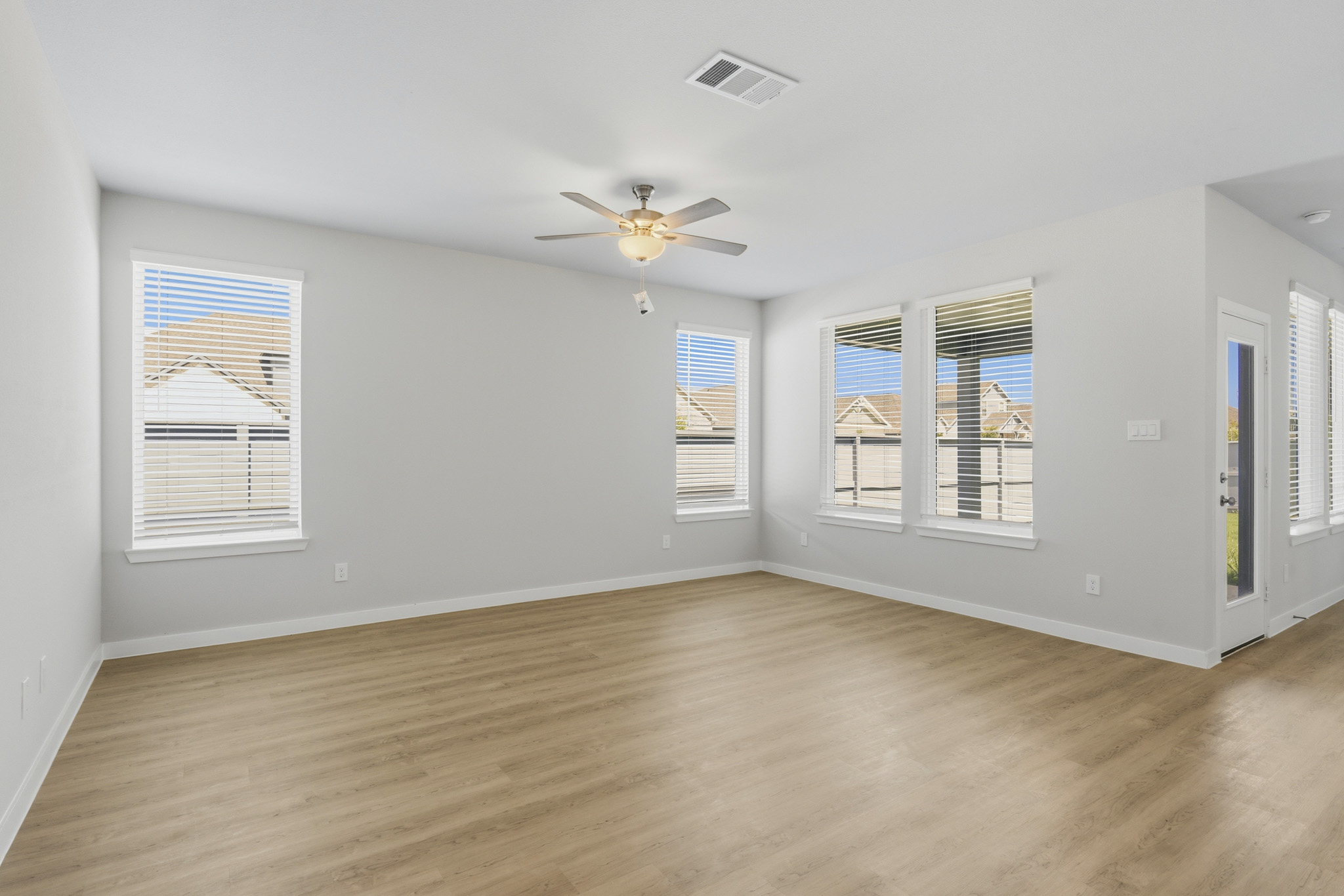 A room with a wood floor and a ceiling fan.