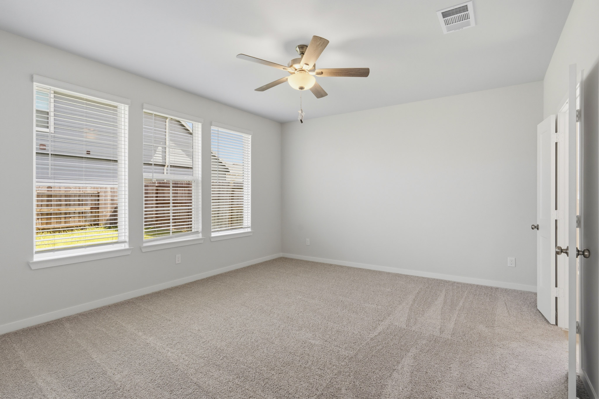 A room with a ceiling fan and a window.